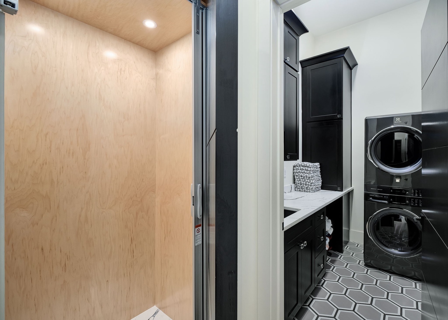 Your sleek laundry room features stackable washer-dryer and ample cabinet storage for effortless stay maintenance.