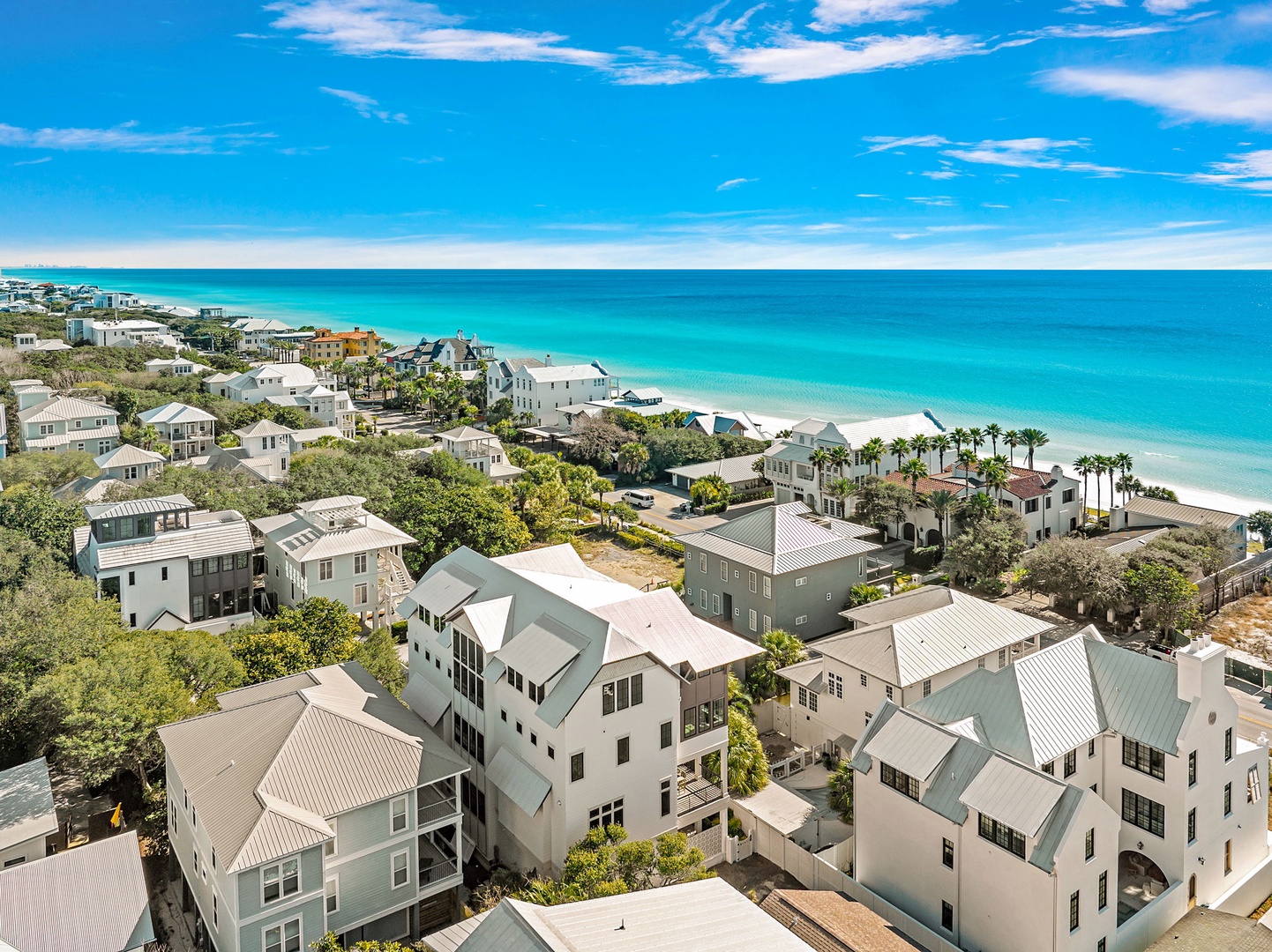 Stunning aerial view showcasing the pristine beachfront community with turquoise waters and white sand beaches just steps away.