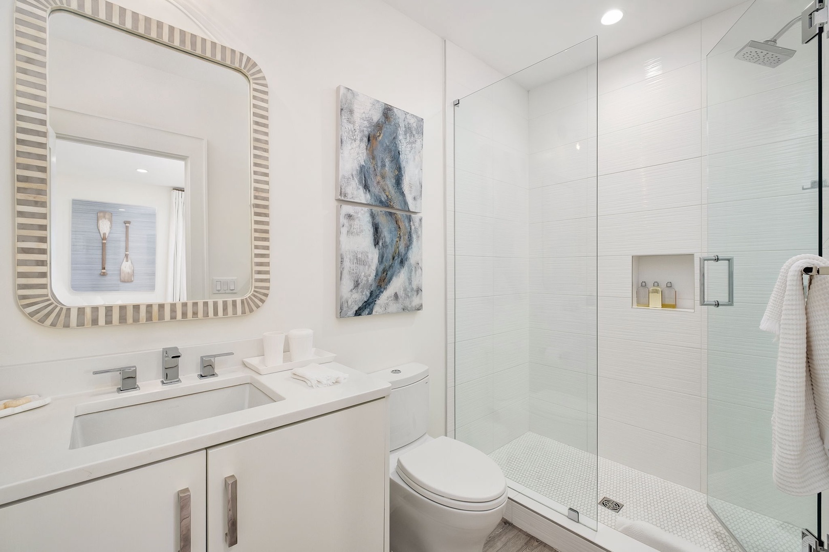 Slip into your private oasis featuring a sleek walk-in shower, a modern vanity, and elegant coastal touches. Everything you need for a refreshing start.