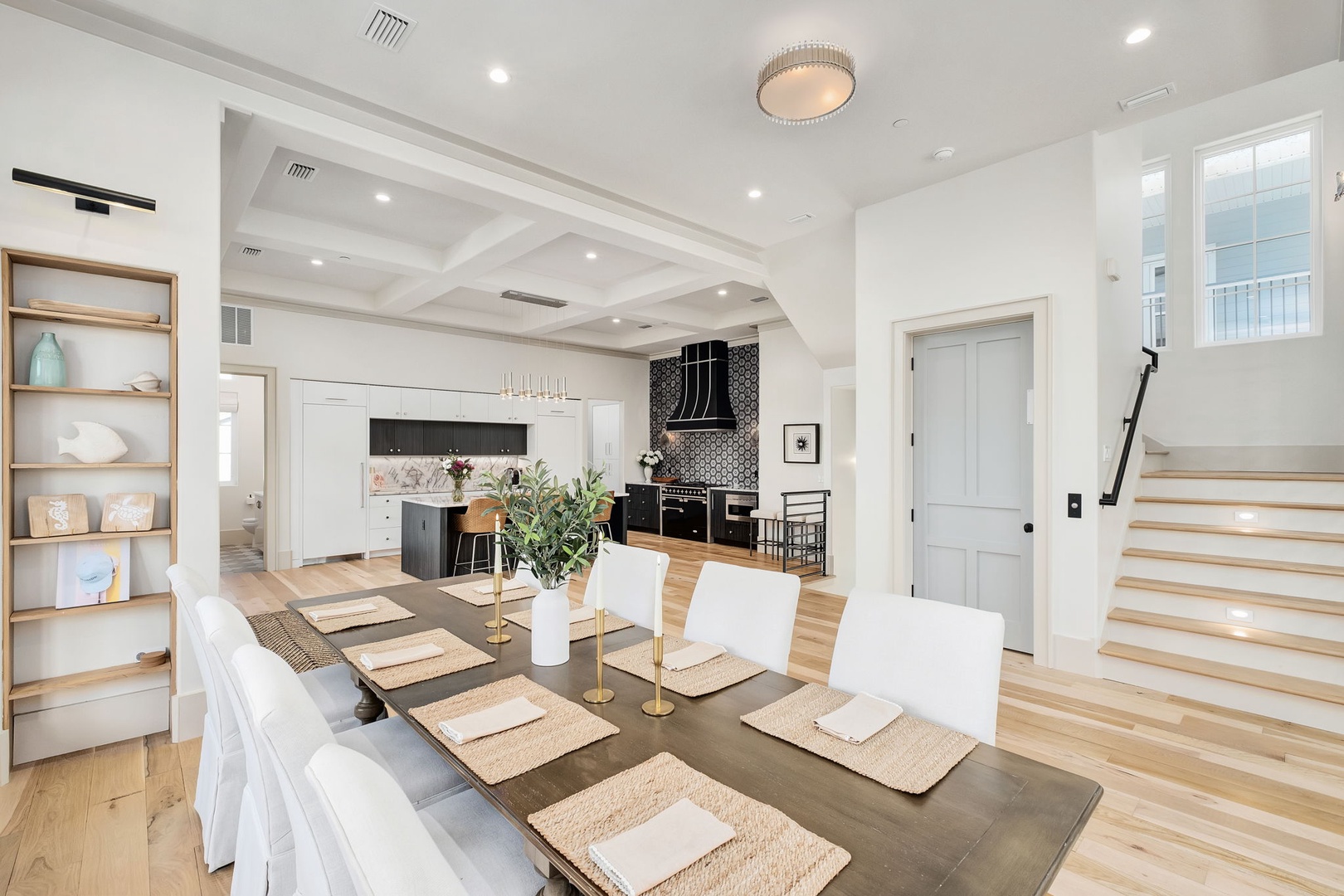 Gather around this stunning dining table where memorable meals unfold beneath soaring coffered ceilings and elegant lighting.