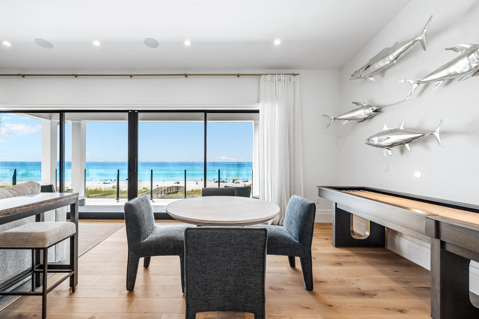 Gather around the dining table and enjoy stunning turquoise waters framed by floor-to-ceiling windows. Your beachside retreat features coastal-inspired décor and direct views that bring the shoreline right into your living space.