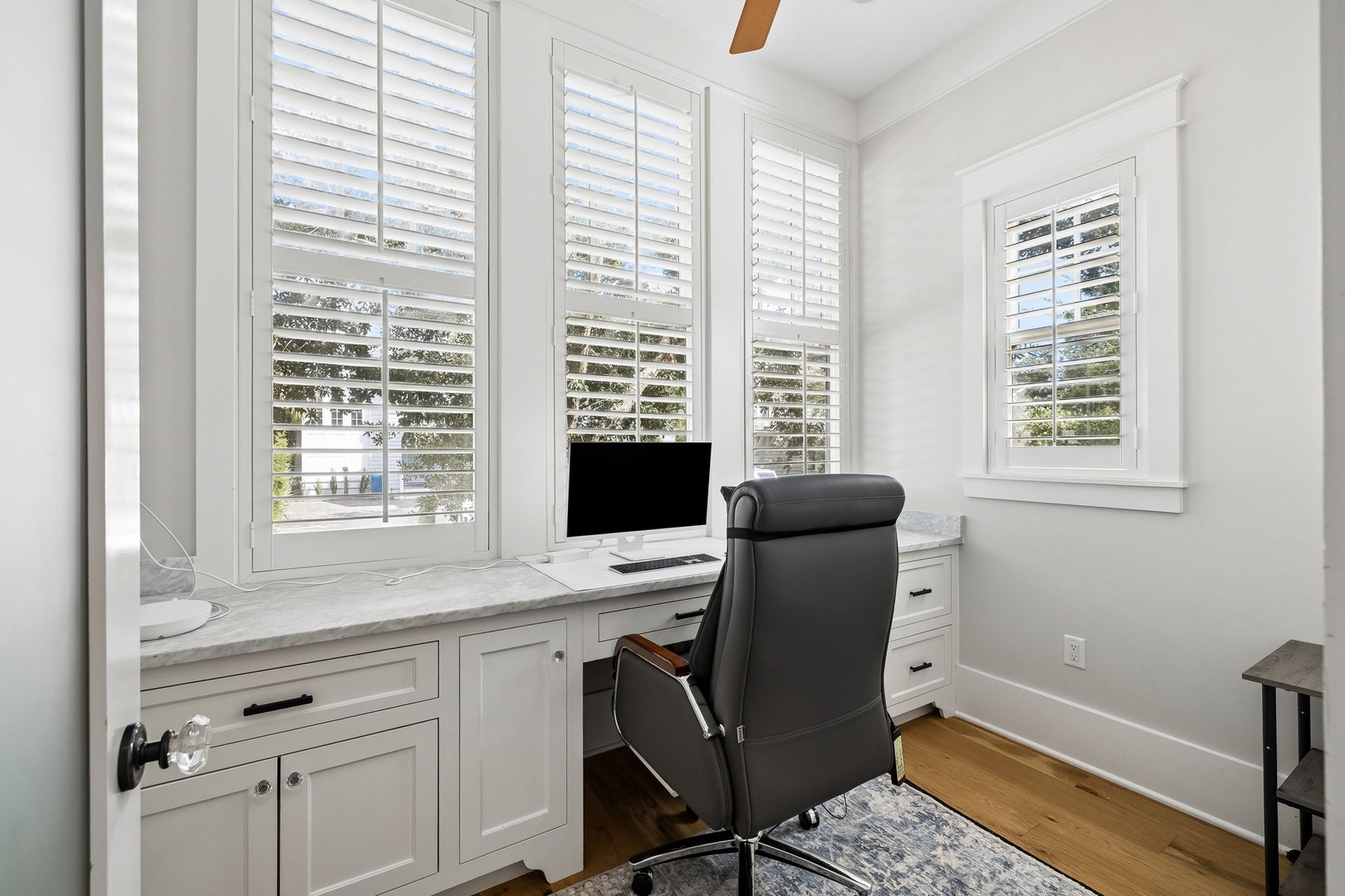 Set up your workspace in this bright corner office, where natural light streams through plantation shutters and a built-in desk gives you plenty of room to work comfortably.