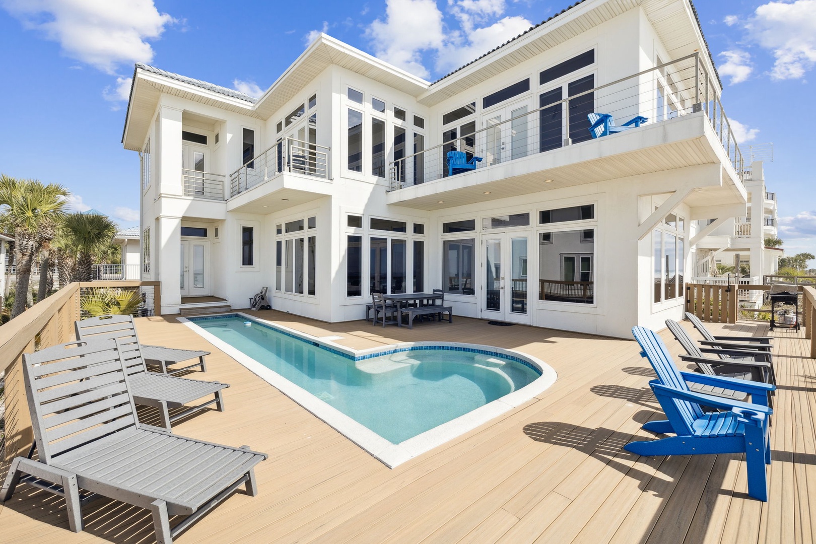 Modern beachfront villa with private pool, spacious deck, and tropical palms creates the perfect coastal retreat.