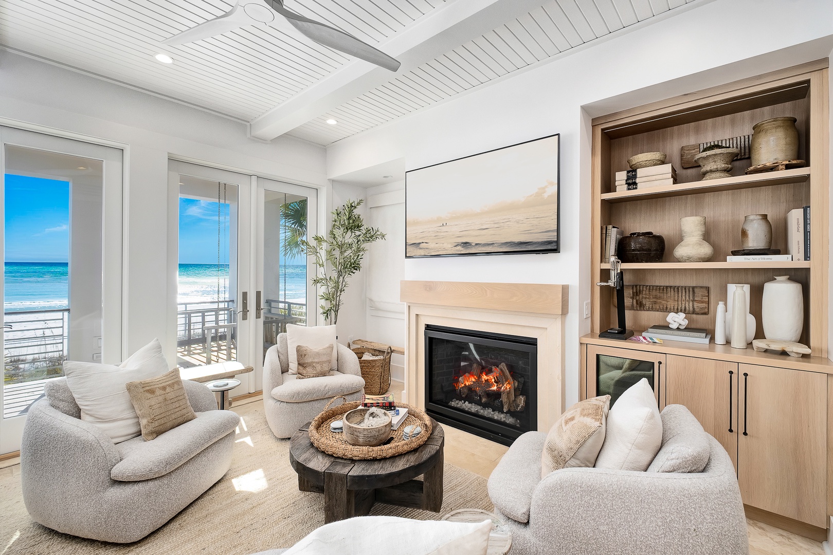 Sink into plush seating by your crackling fireplace while ocean waves sparkle through floor-to-ceiling windows in this coastal paradise.