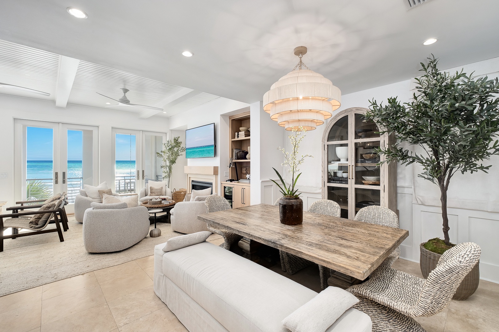 Your elegant beachfront retreat features an open living space where natural textures meet ocean views through floor-to-ceiling windows.