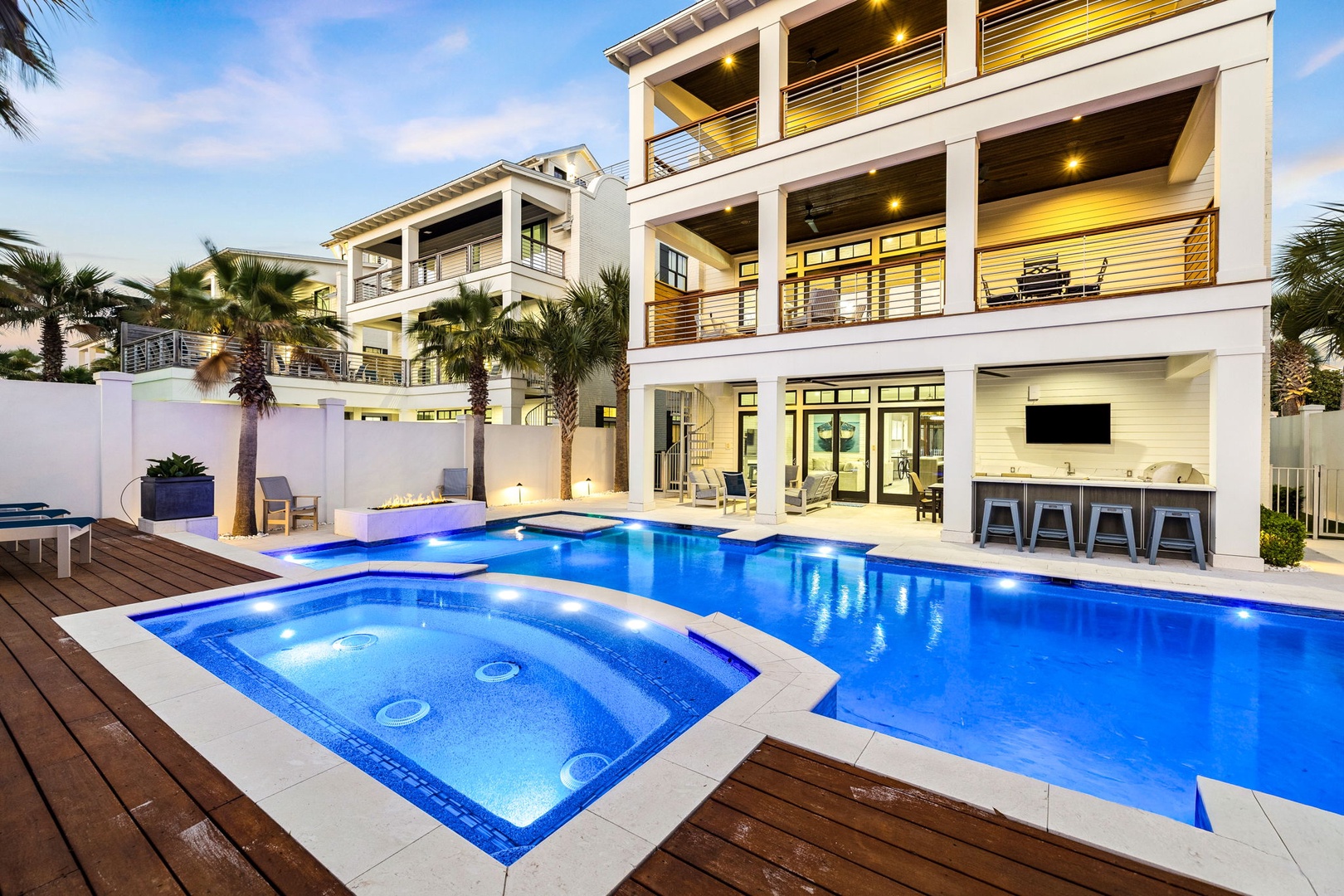 Modern luxury vacation home with stunning pool, spa, and tropical landscaping in an upscale neighborhood setting.