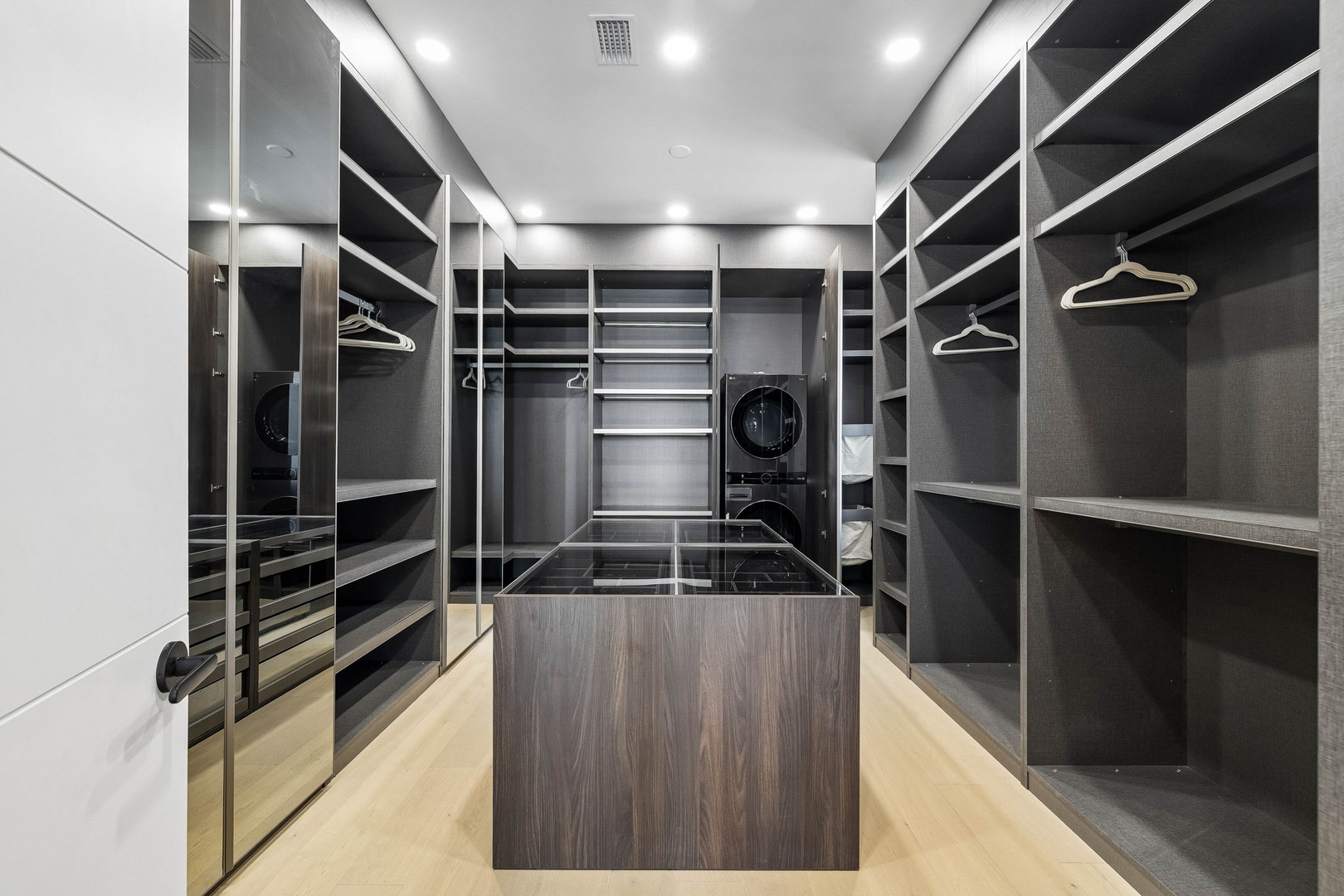 Your private walk-in closet offers generous hanging space, custom shelving, and a sleek center island for effortless unpacking and organization.
