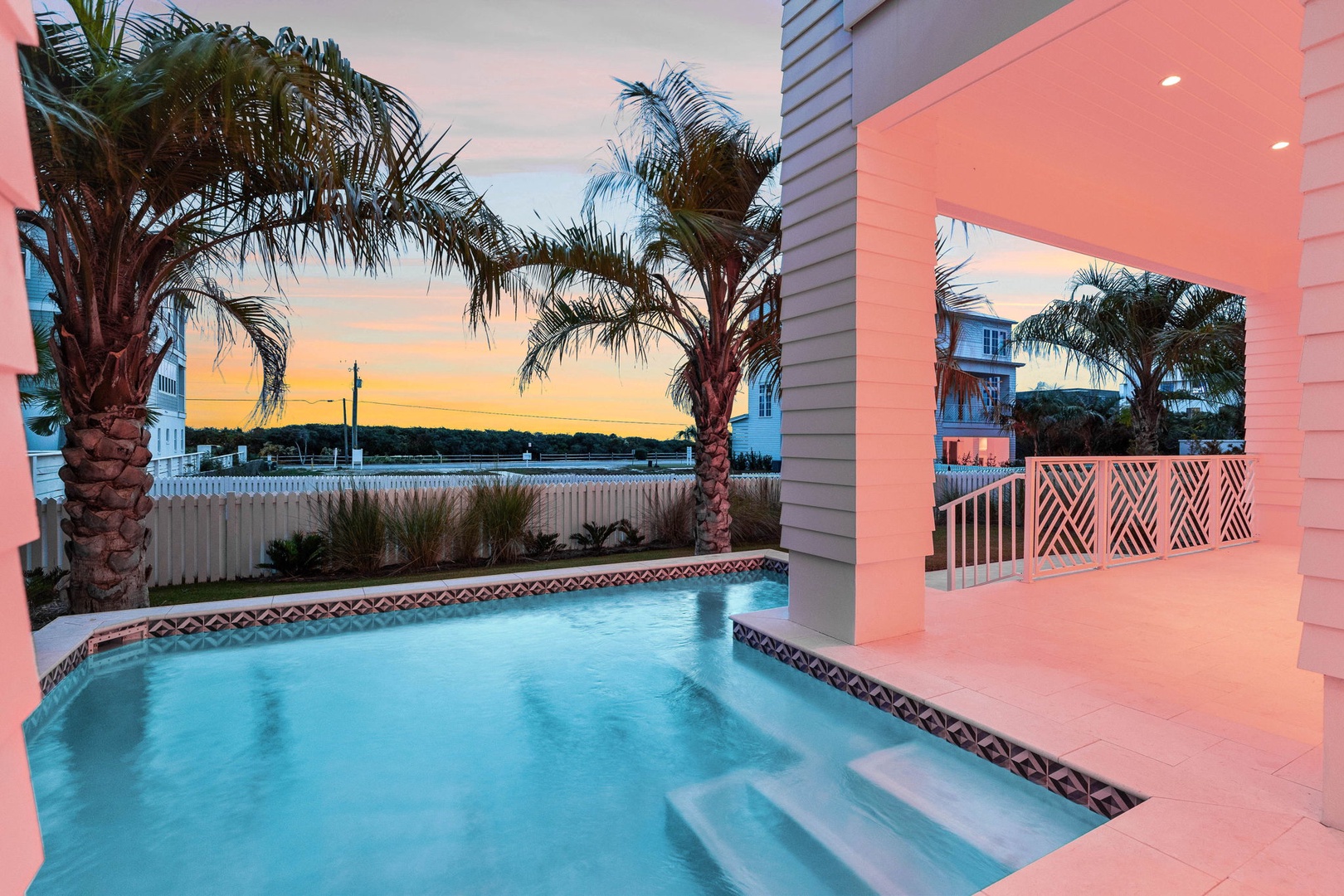Slip into your private pool as golden sunset paints the sky, with swaying palms framing water views beyond.