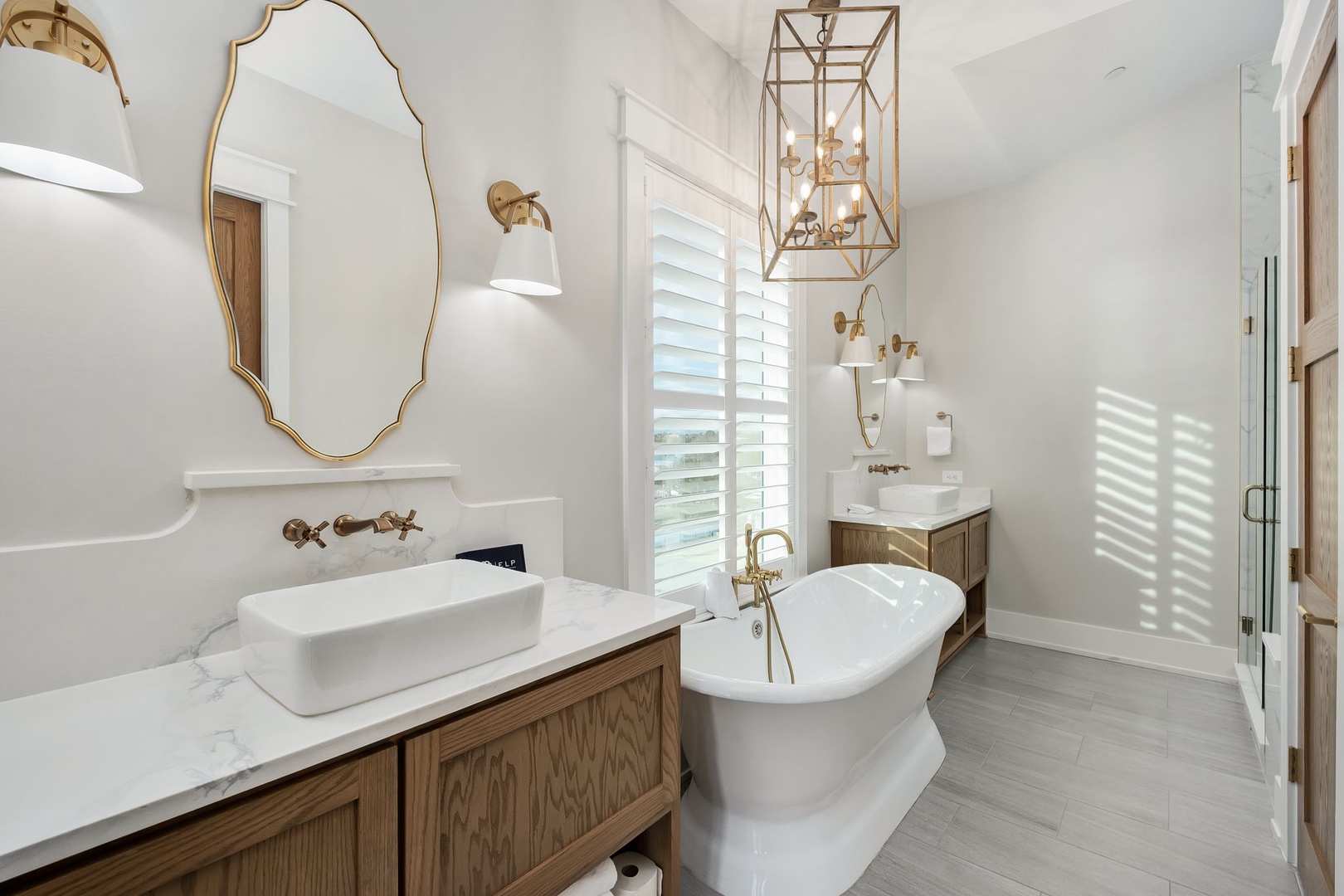 Luxurious bathroom featuring elegant freestanding tub, marble counters, and gold fixtures for your perfect relaxation retreat.