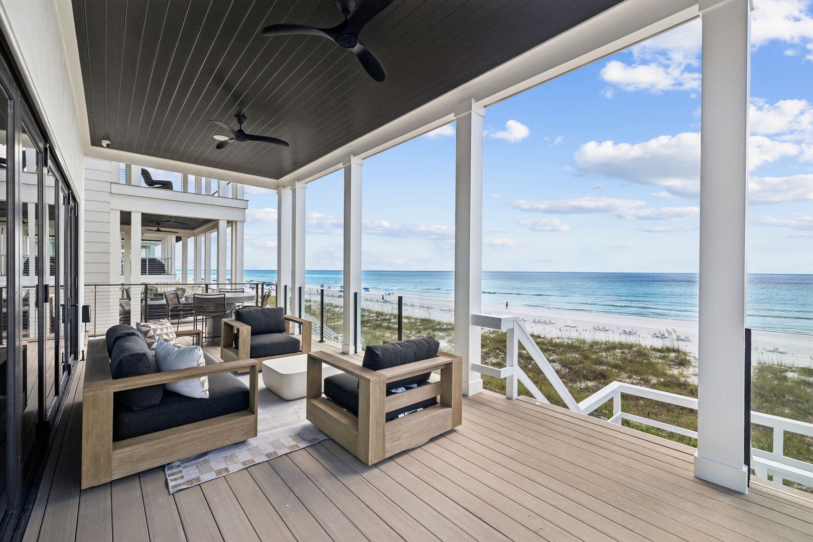 Unwind on your private covered deck where ocean breezes meet modern comfort, with sweeping views of pristine white sand and gentle waves just steps away.