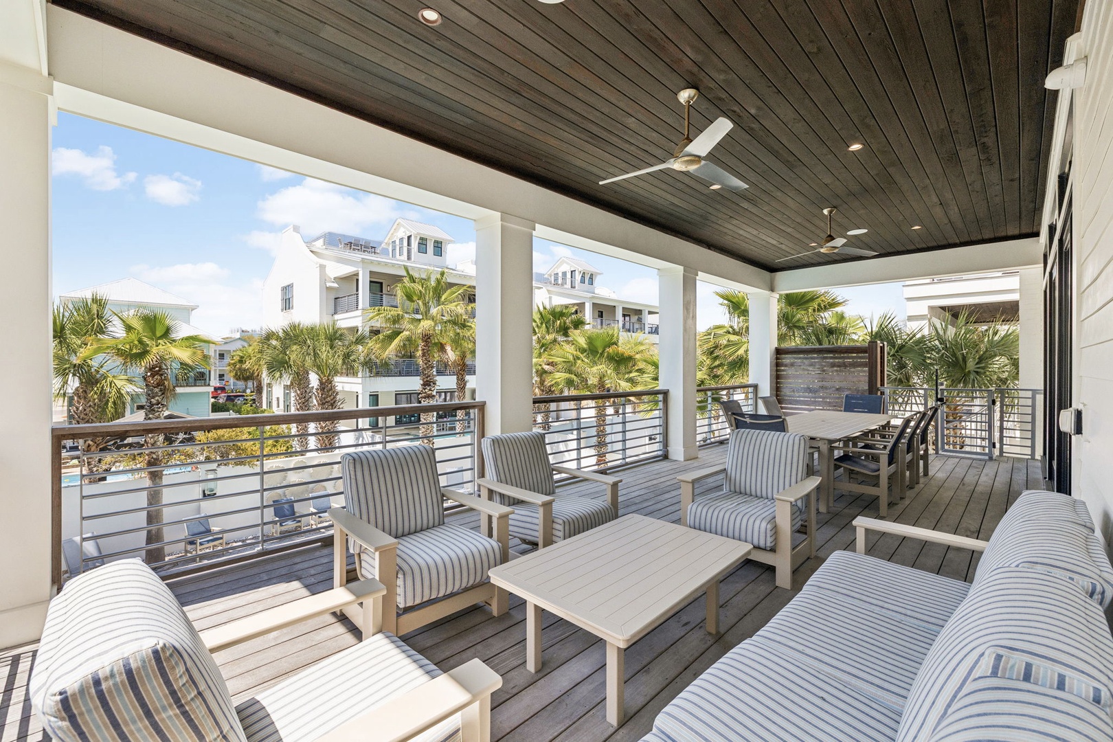 Unwind on your private covered terrace with comfortable seating and stunning views of tropical palms and coastal homes.