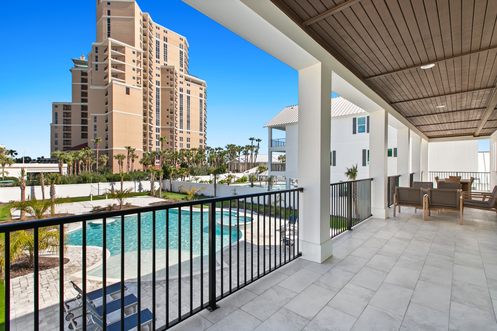 Your private covered balcony overlooks the sparkling pool and tropical palms, offering a peaceful spot to relax with your morning coffee or evening wind-down.