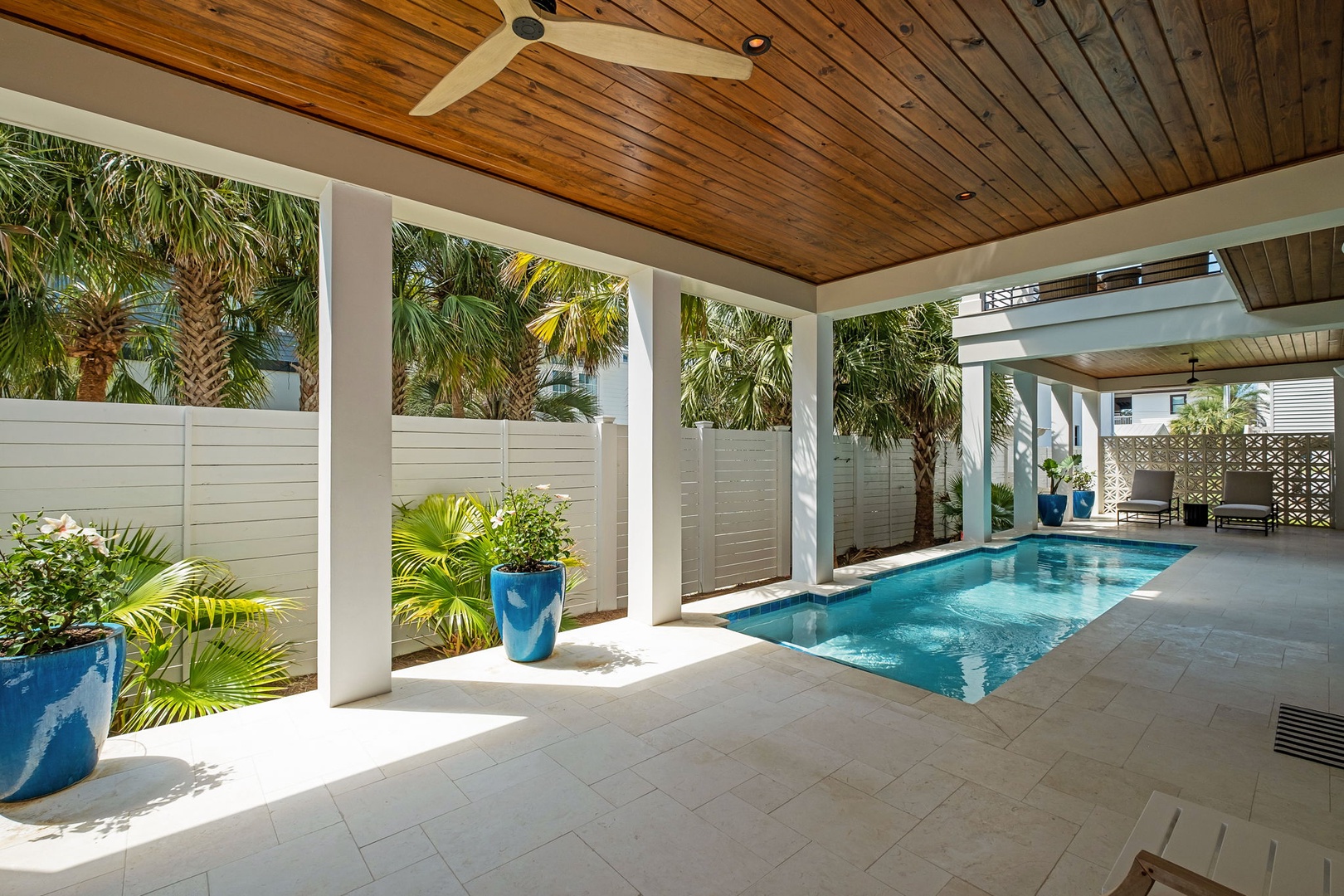 Step into your private tropical oasis where warm wood ceilings frame your secluded pool paradise.