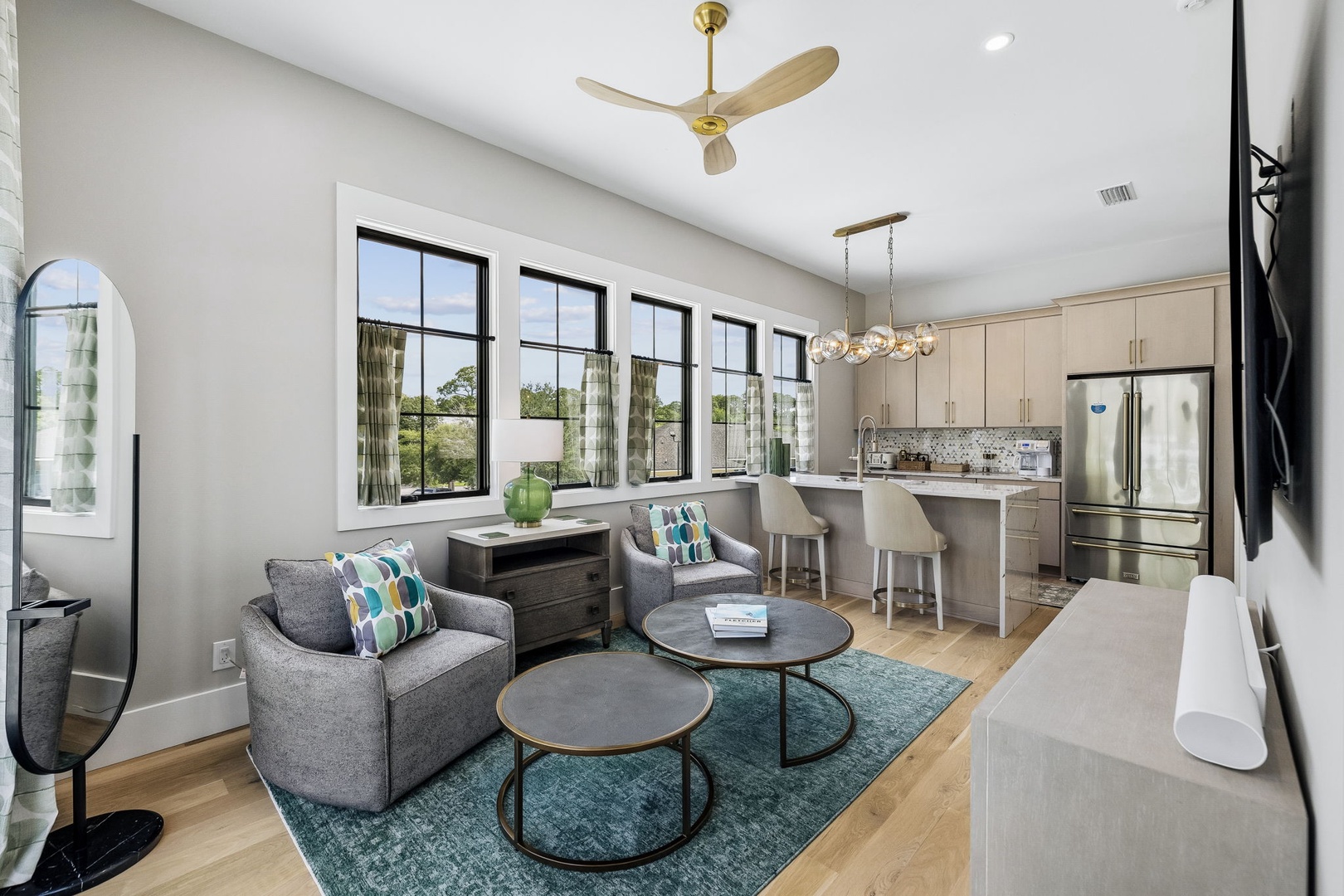 Settle into your light-filled open living space where modern comfort meets effortless style. Relax in the cozy seating, whip up meals in your sleek kitchen, and enjoy natural light streaming through expansive windows overlooking serene greenery.