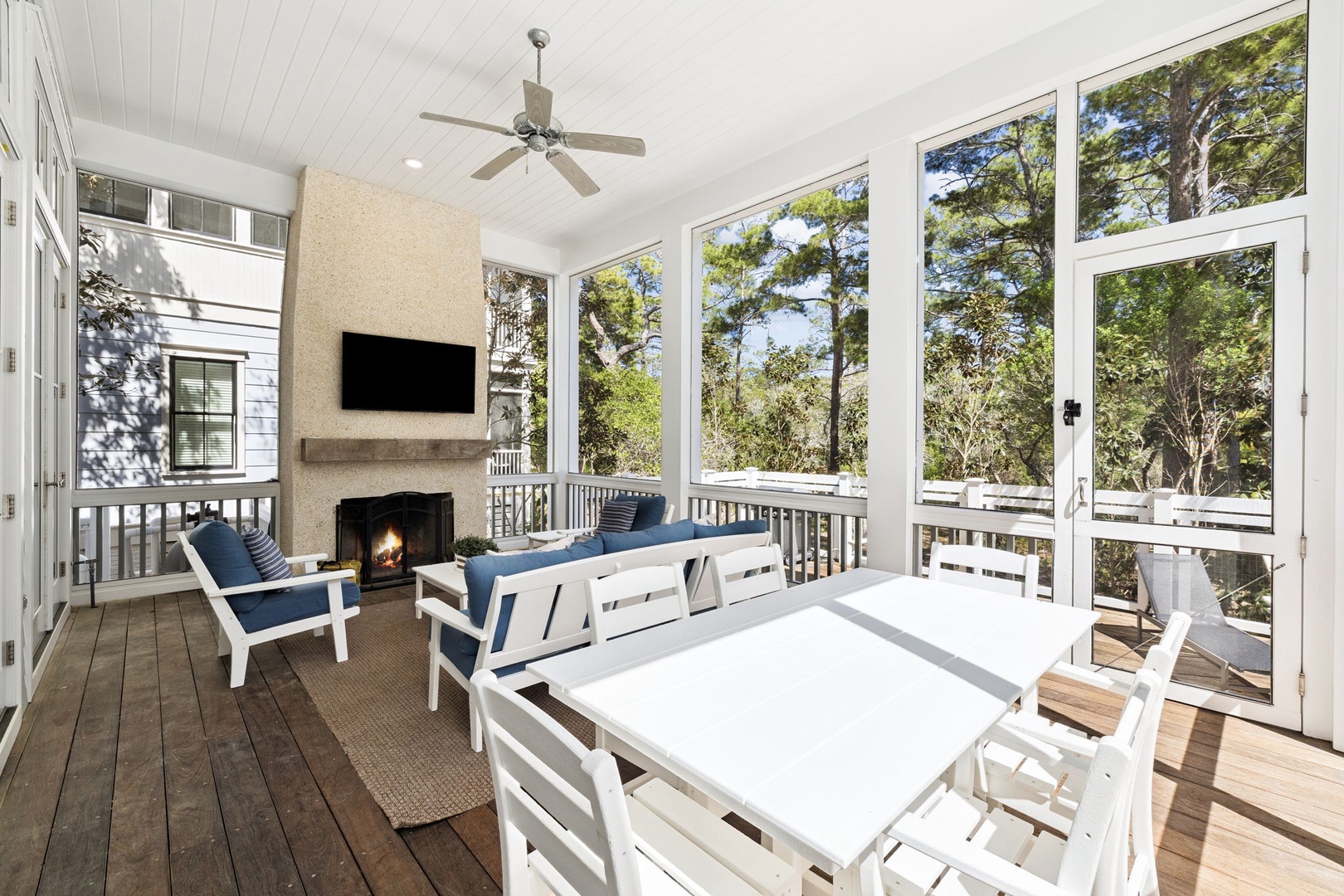 Your covered porch offers cozy seating by the fireplace with peaceful forest views through floor-to-ceiling windows.