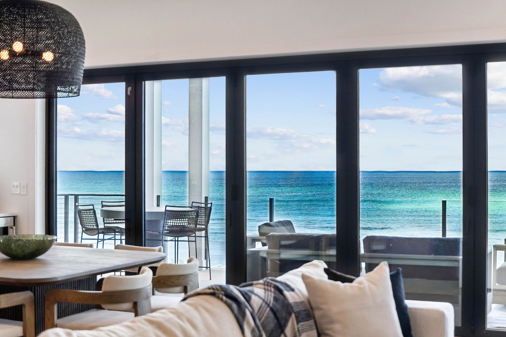 Relax in your living space with stunning ocean views stretching endlessly before you. Floor-to-ceiling windows frame the turquoise water, filling your home with natural light and coastal serenity.