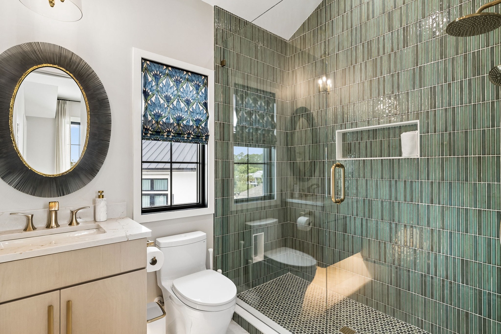 Step into your luxurious bathroom featuring stunning green mosaic tile and a spacious walk-in shower. Gold accents and a statement mirror add elegance to your refreshing retreat.