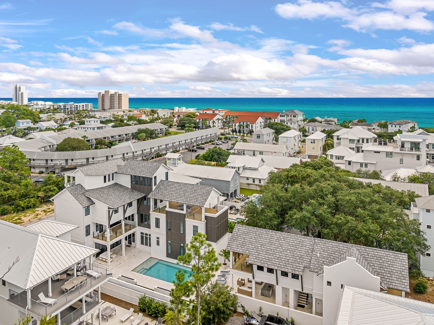 An aerial perspective showcasing the coastal neighborhood, with the stunning turquoise Gulf waters and nearby beaches just beyond the rooftops.