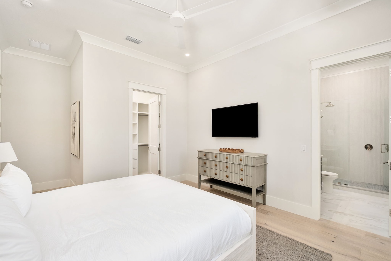 Unwind in your serene bedroom featuring crisp linens, a wall-mounted TV for entertainment, and your own private ensuite bathroom.