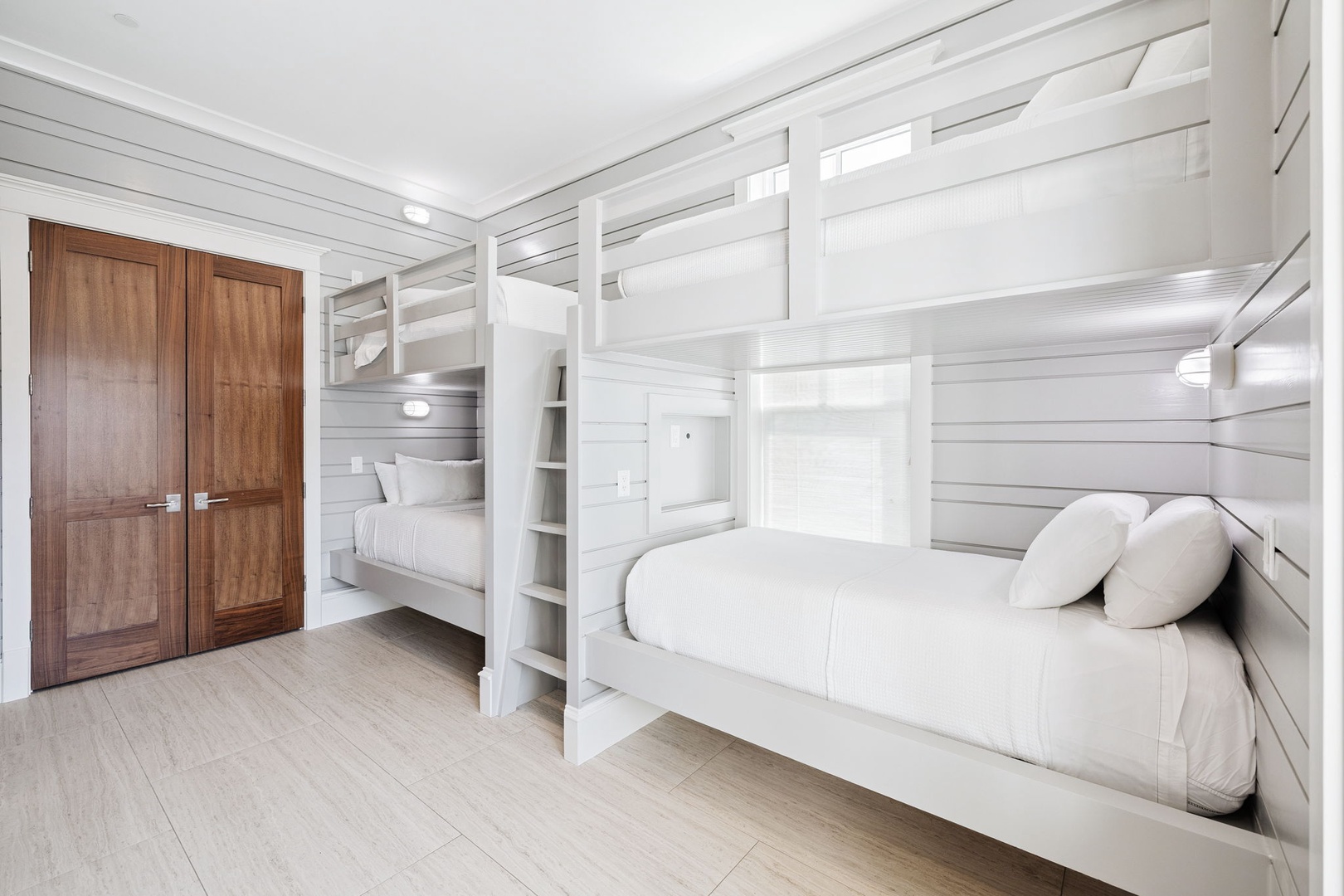 Your coastal-inspired bunk room features built-in beds with crisp white linens and individual reading lights for restful nights.
