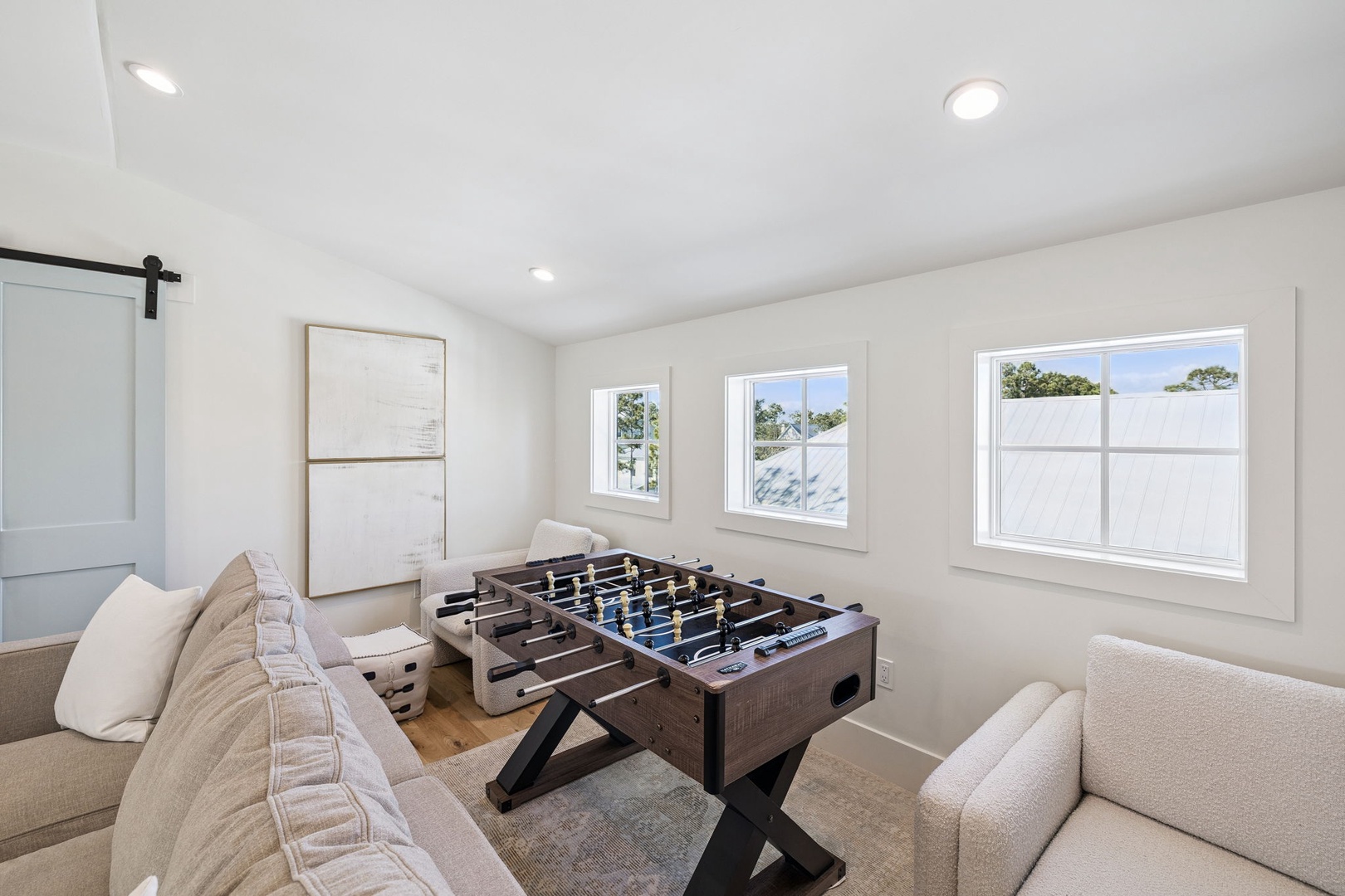 Challenge your family to friendly foosball matches in this bright game room, where natural light streams through multiple windows.