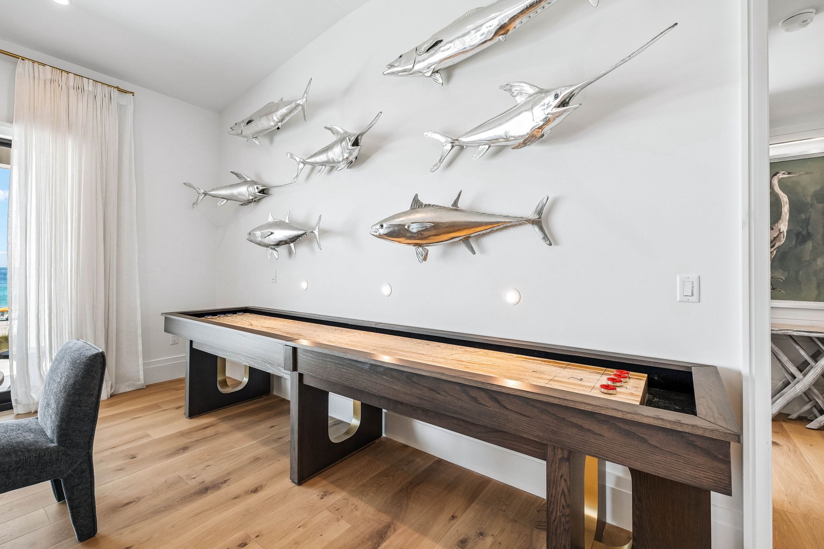 Challenge your friends to a friendly game on the custom shuffleboard table, surrounded by coastal-inspired décor that brings the ocean indoors.