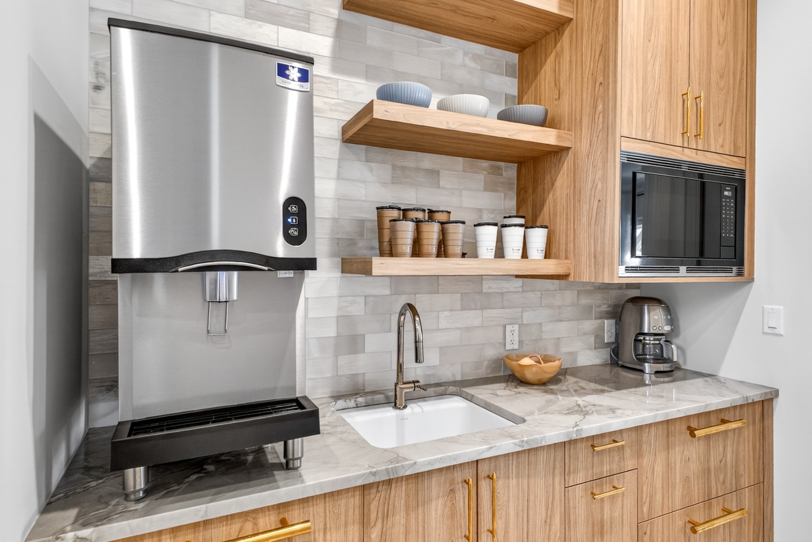 Your fully equipped kitchen features warm wood cabinetry, marble countertops, and modern appliances—perfect for brewing morning coffee or preparing a home-cooked meal during your stay.