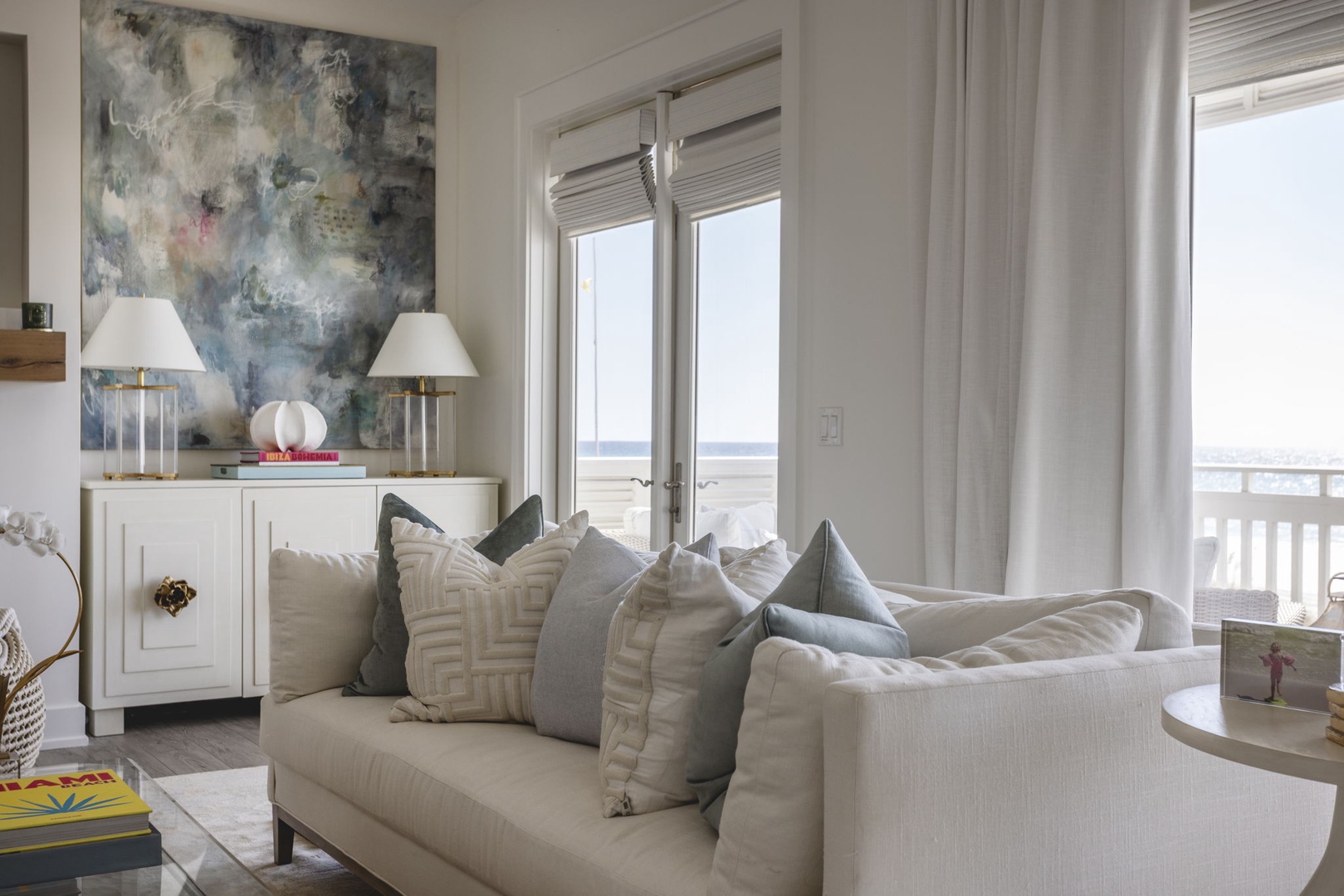 Sink into plush cushions while gazing at endless ocean views from your living room. Abstract art and warm lighting create the perfect ambiance for relaxation.