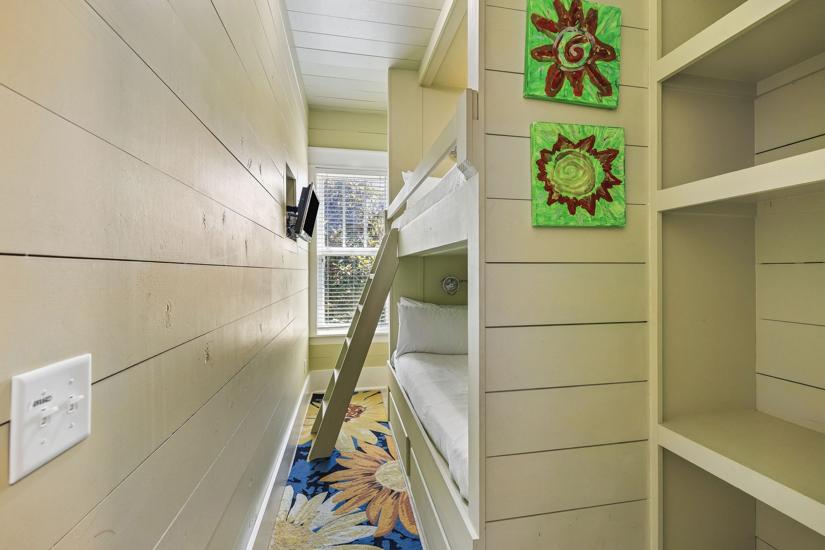 Cheerful bunk nook designed for restful nights, with bright artwork adding a playful touch to your stay.