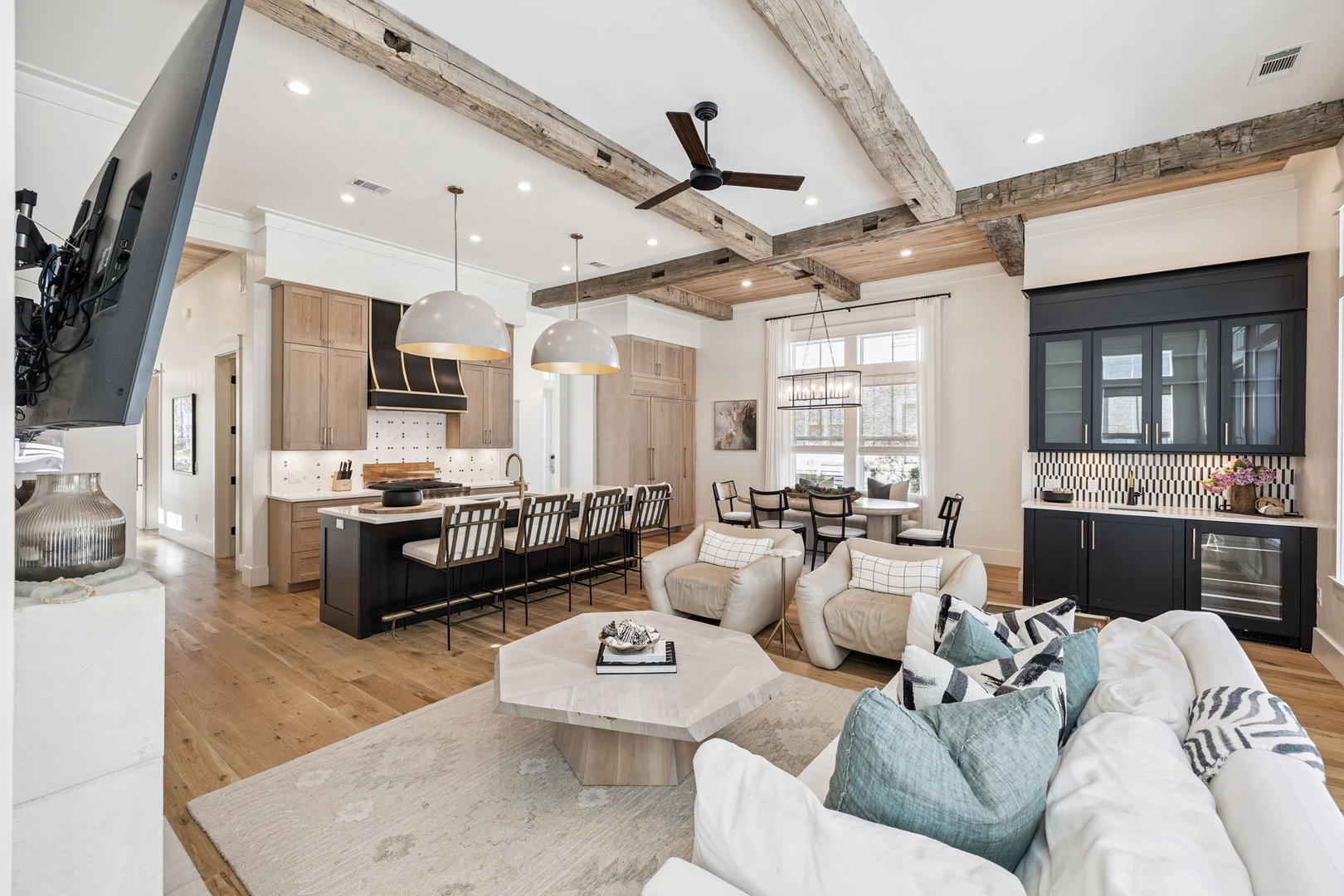 Sink into plush seating beneath rustic wood beams while your group gathers around the sleek kitchen island.