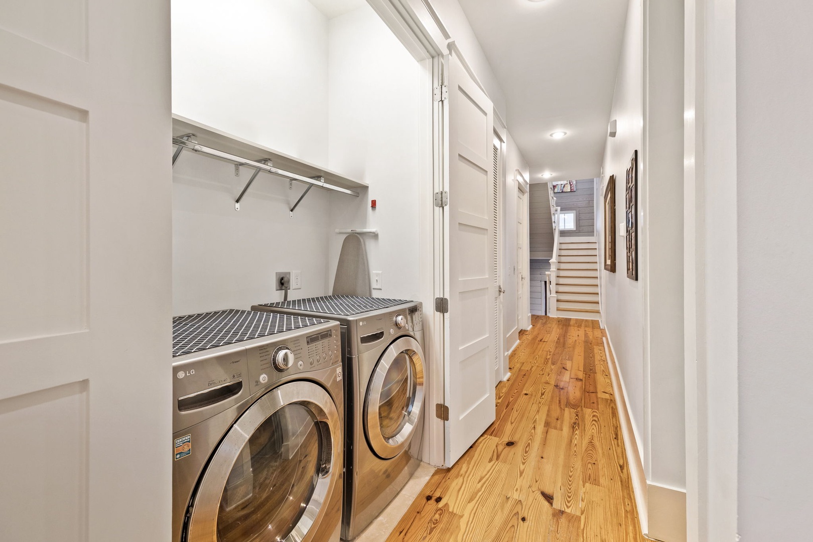Your in-unit washer and dryer set sits tucked into its own alcove with hanging space above—effortless laundry days throughout your stay.