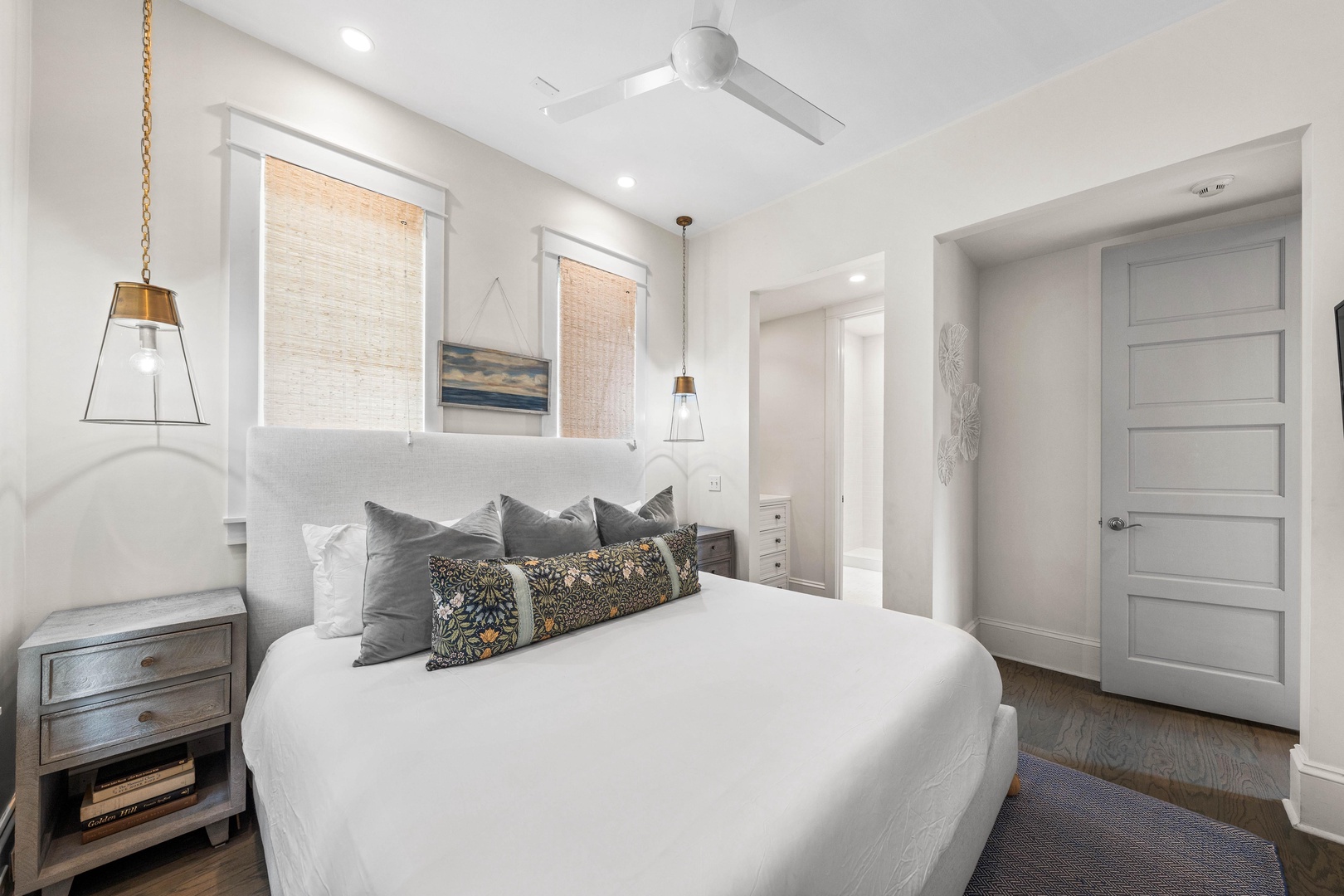 Sink into crisp white linens surrounded by modern elegance and warm pendant lighting in your tranquil retreat.