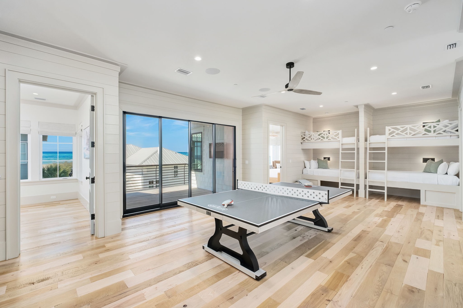 Your beach getaway features bunk beds, ping pong table, and stunning ocean views from glass doors.