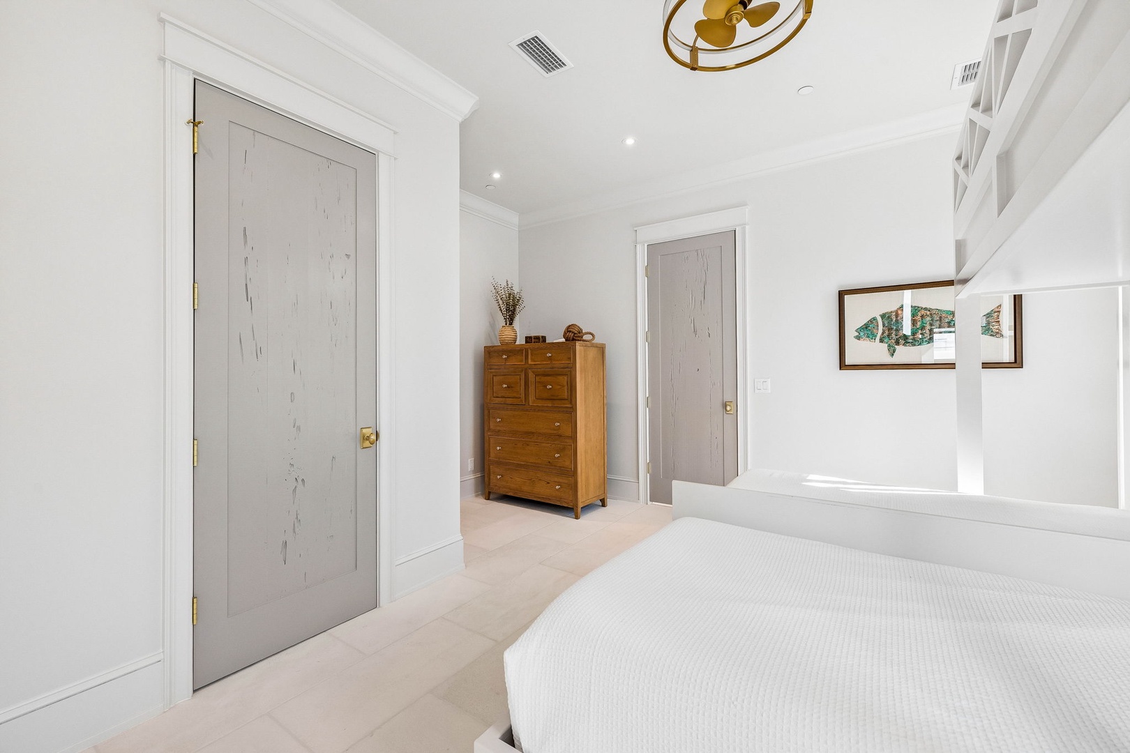 Your serene bedroom retreat features crisp white linens, built-in shelving, and coastal charm—a peaceful space designed for restful nights and relaxing mornings.