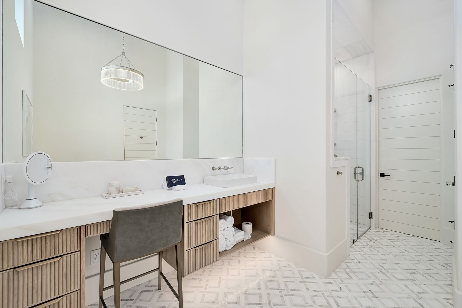 Step into your private spa-like bathroom, where a vanity desk invites you to start each morning feeling pampered and refreshed in this bright, serene space.