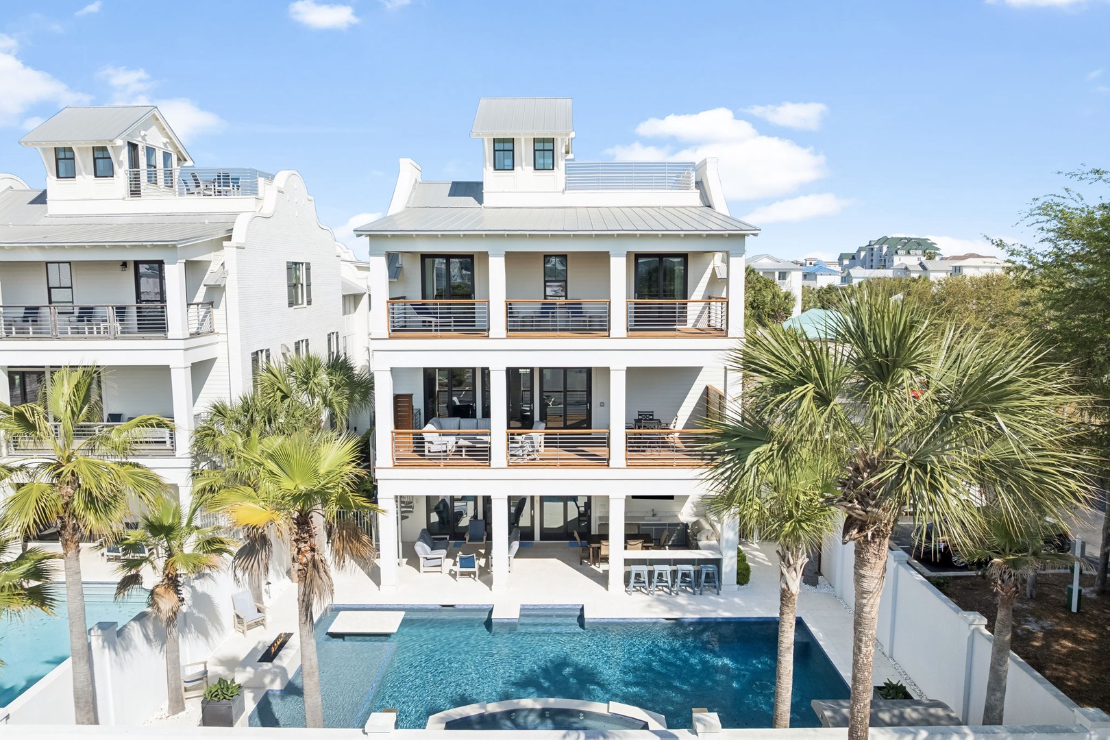 Modern coastal property featuring a stunning three-story design with private pool and tropical landscaping.