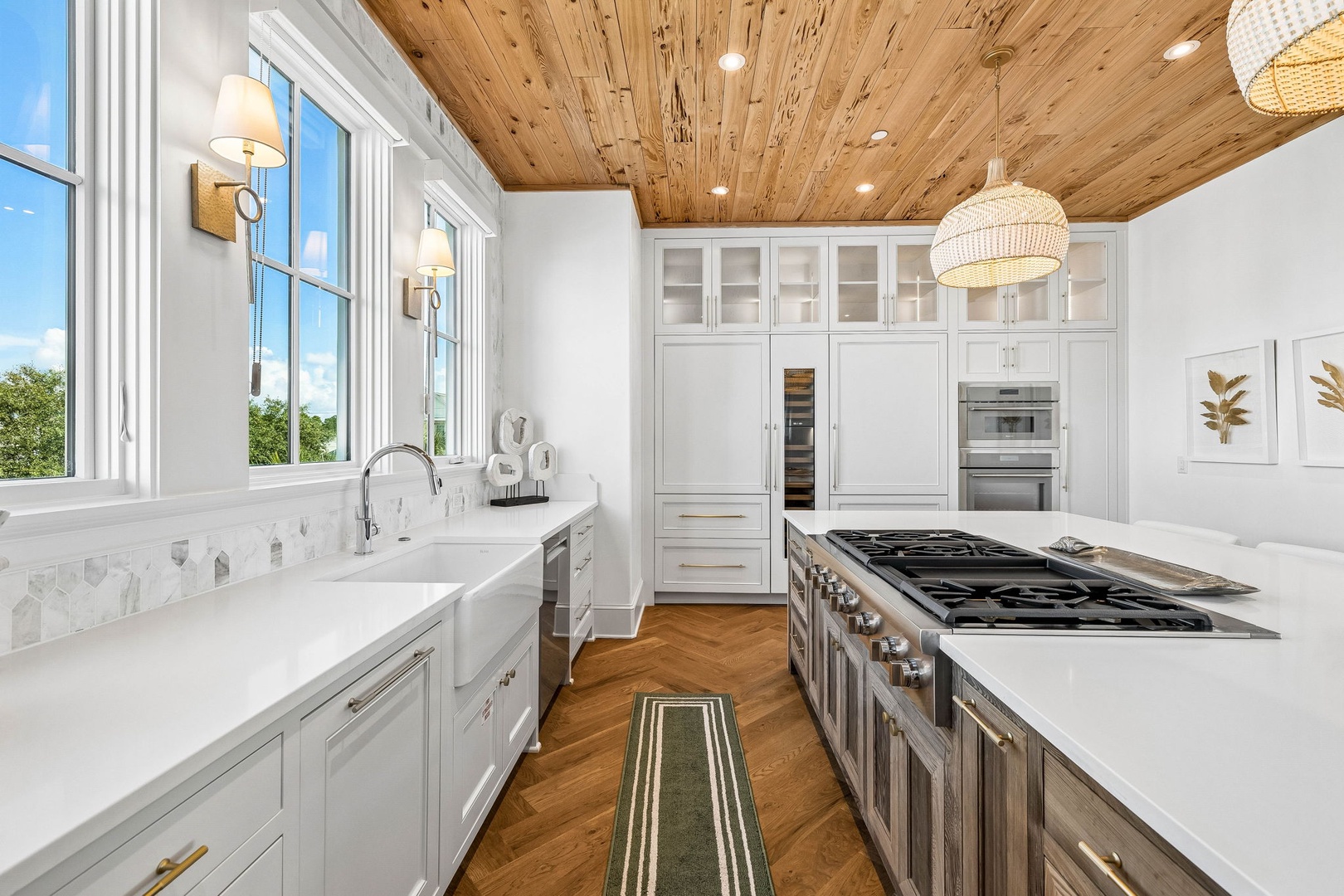 Picture yourself preparing meals in this sun-drenched kitchen with stunning wood ceilings and premium appliances. Natural light pours through expansive windows, illuminating sleek countertops and professional-grade cookware—your culinary haven awaits.