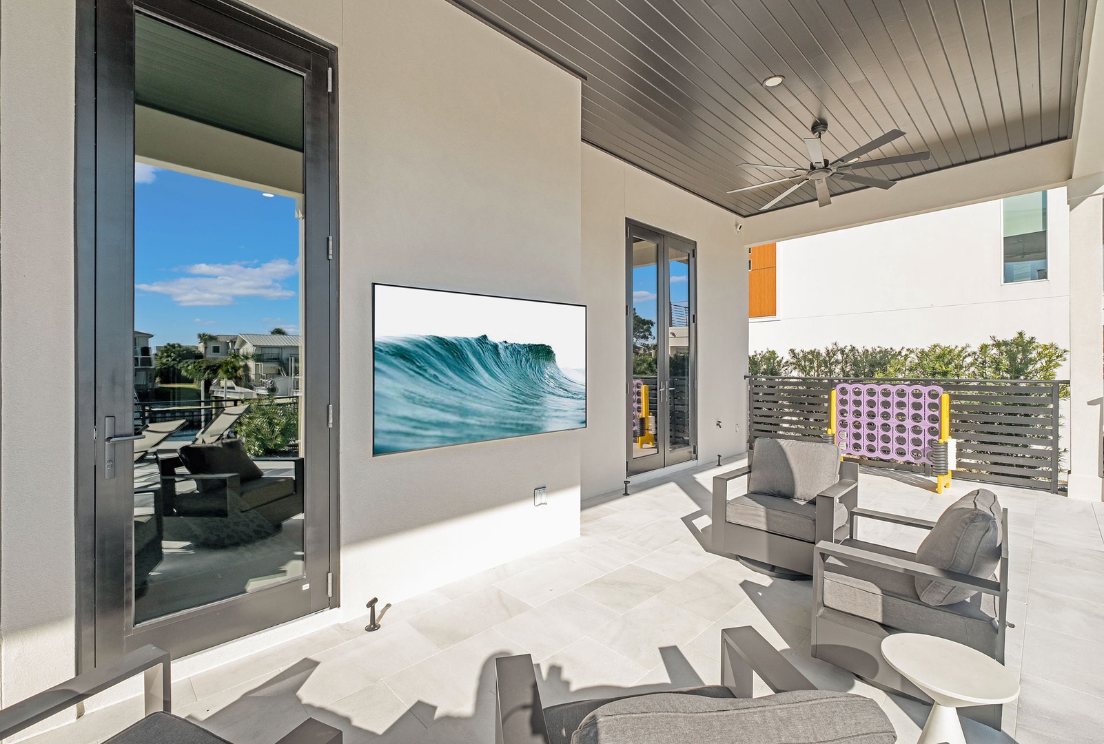 Your stylish outdoor terrace features plush seating and a large TV for relaxing entertainment under the covered ceiling.