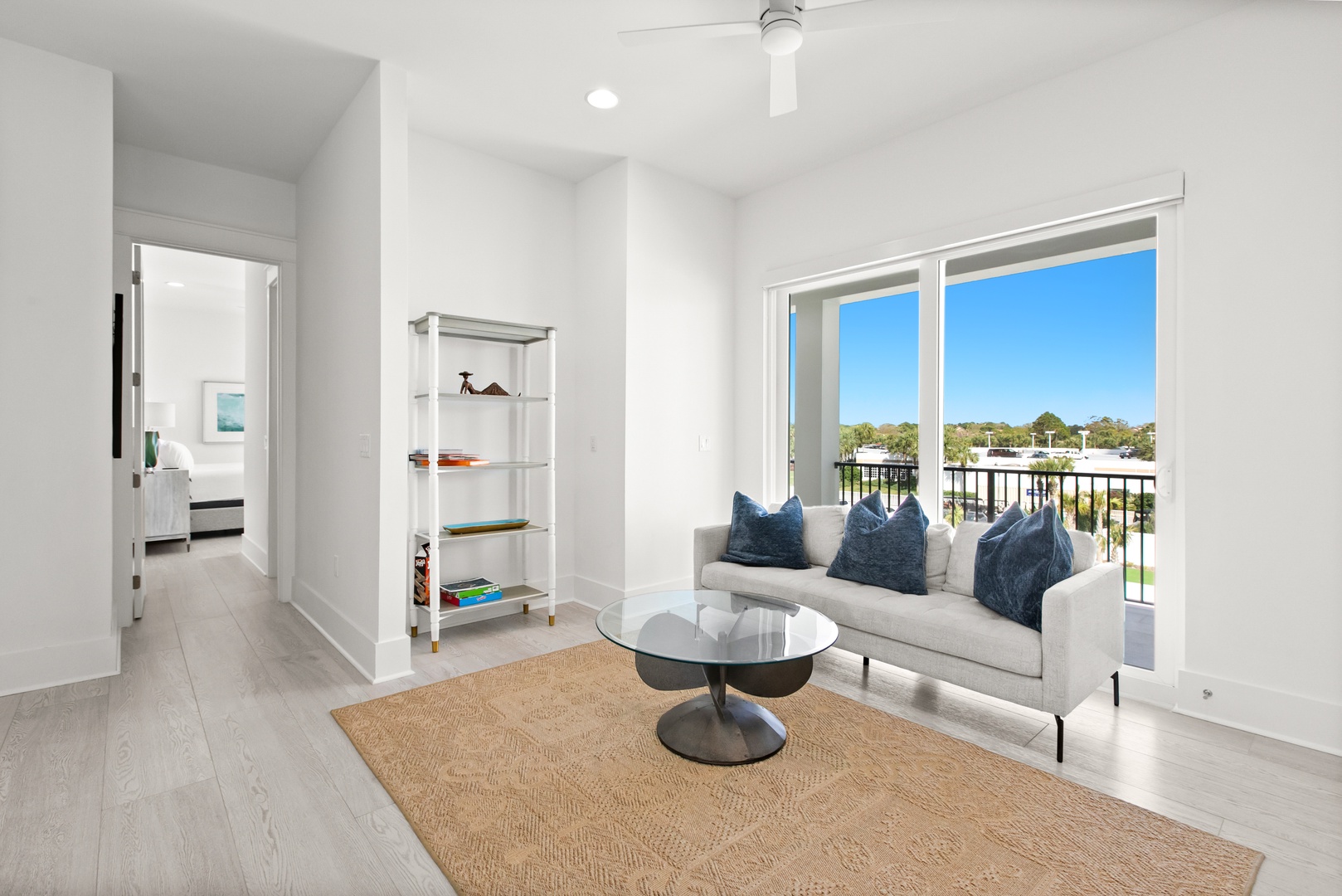 Settle into this bright living room where modern comfort meets fresh air. Through the glass doors, your private balcony overlooks leafy greenery—perfect for morning coffee or unwinding after exploring.