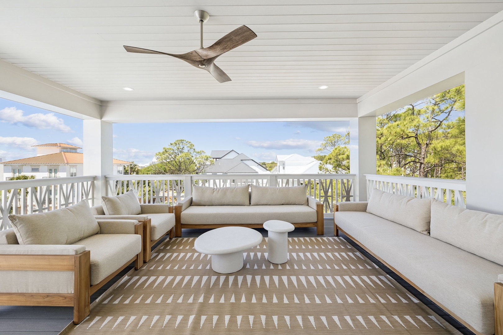 Relax in your private covered balcony with plush seating and peaceful neighborhood views surrounded by lush greenery.