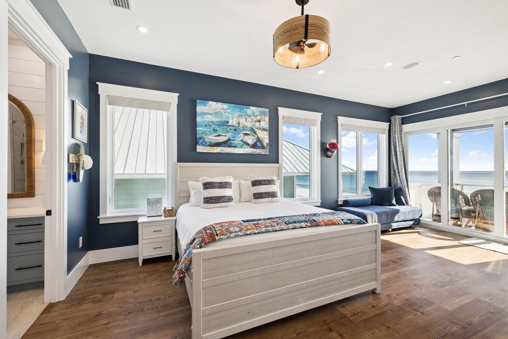 Wake up to breathtaking ocean views in your coastal haven with rich blue walls and warm hardwood floors creating the perfect beachside retreat.