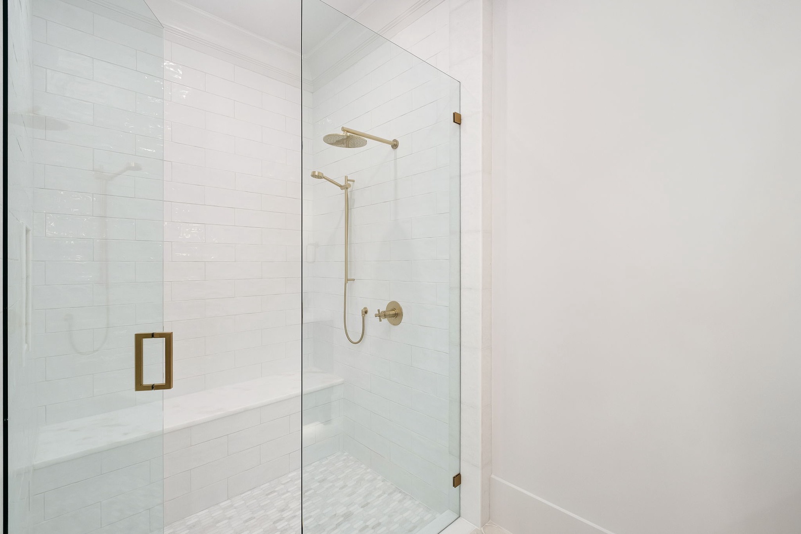 Step into your luxurious glass-enclosed shower featuring elegant subway tiles and premium brass fixtures for an indulgent start to your day.