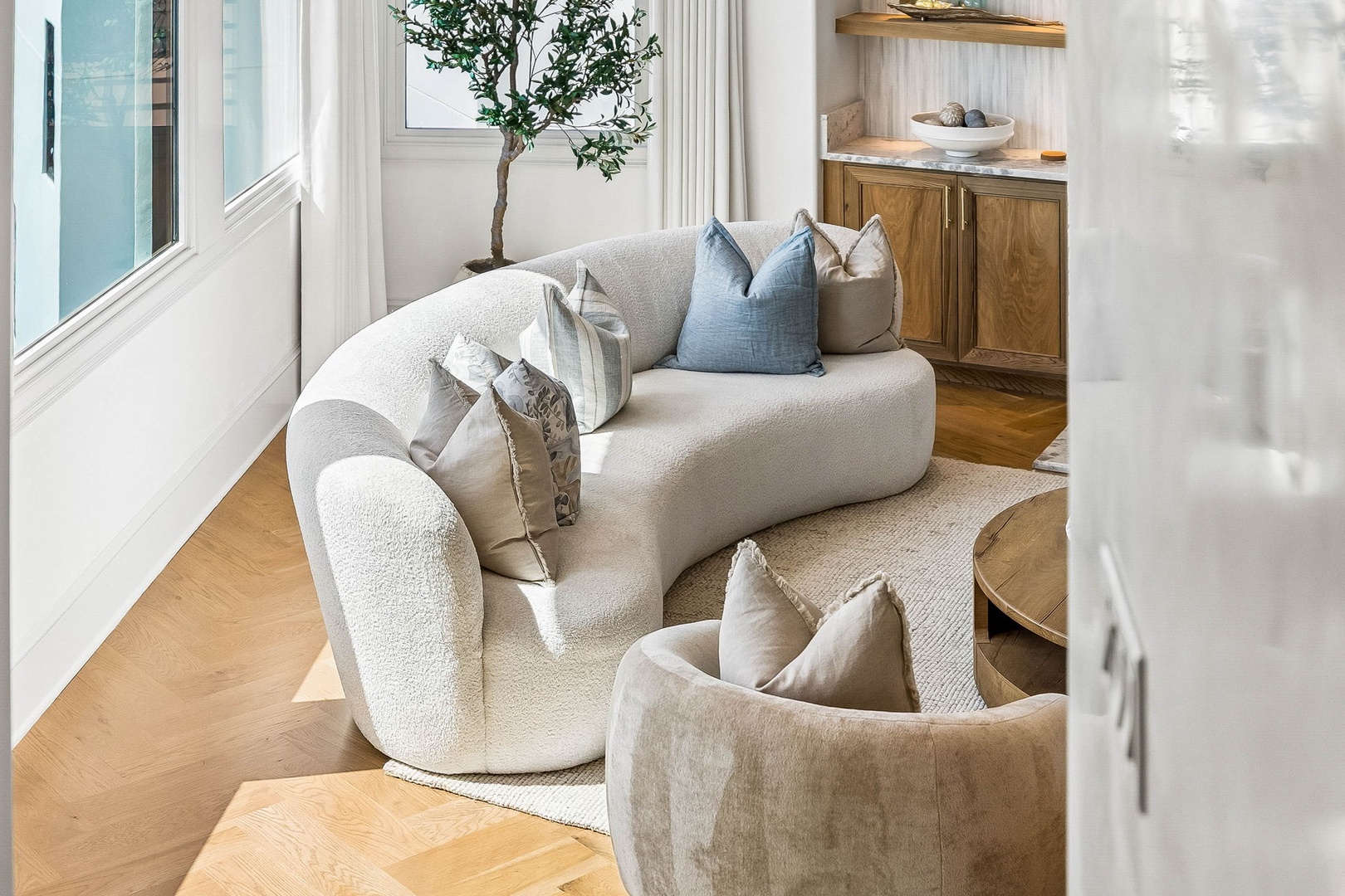 Sink into plush curved seating surrounded by soft natural light and calming coastal tones—your peaceful retreat for unwinding after a day of adventure.