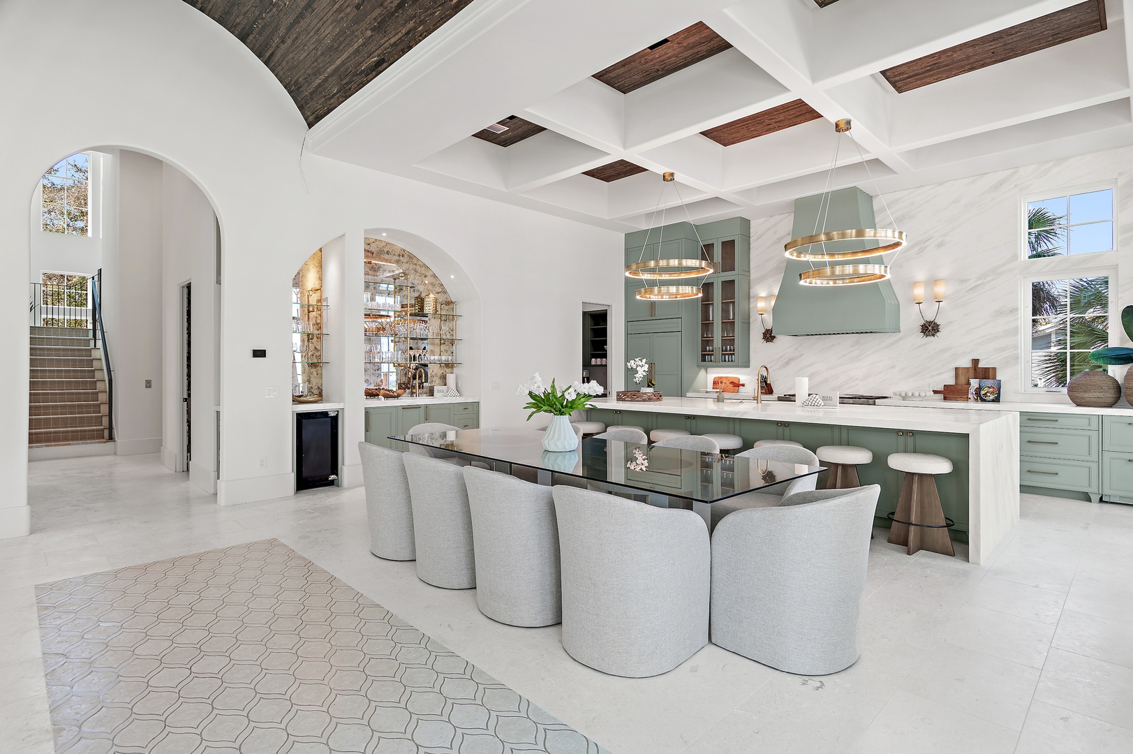 Step into your culinary haven featuring soaring coffered ceilings, elegant sage cabinetry, and a stunning marble island perfect for gathering and creating memories together.