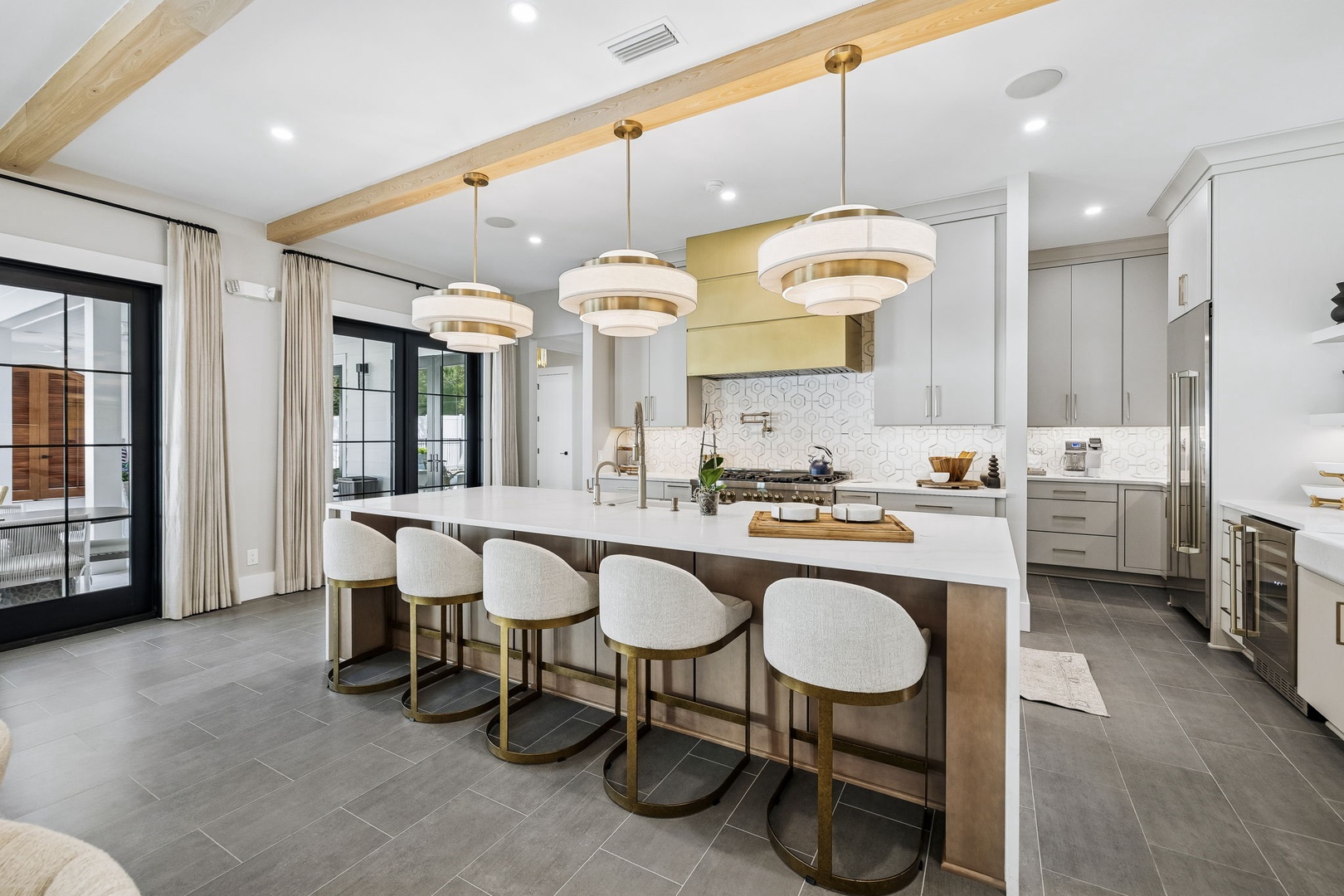 You'll love gathering around this stunning kitchen island with its sleek white countertops and modern pendant lighting. The open design flows seamlessly between cooking and conversation, perfect for creating memorable meals together.