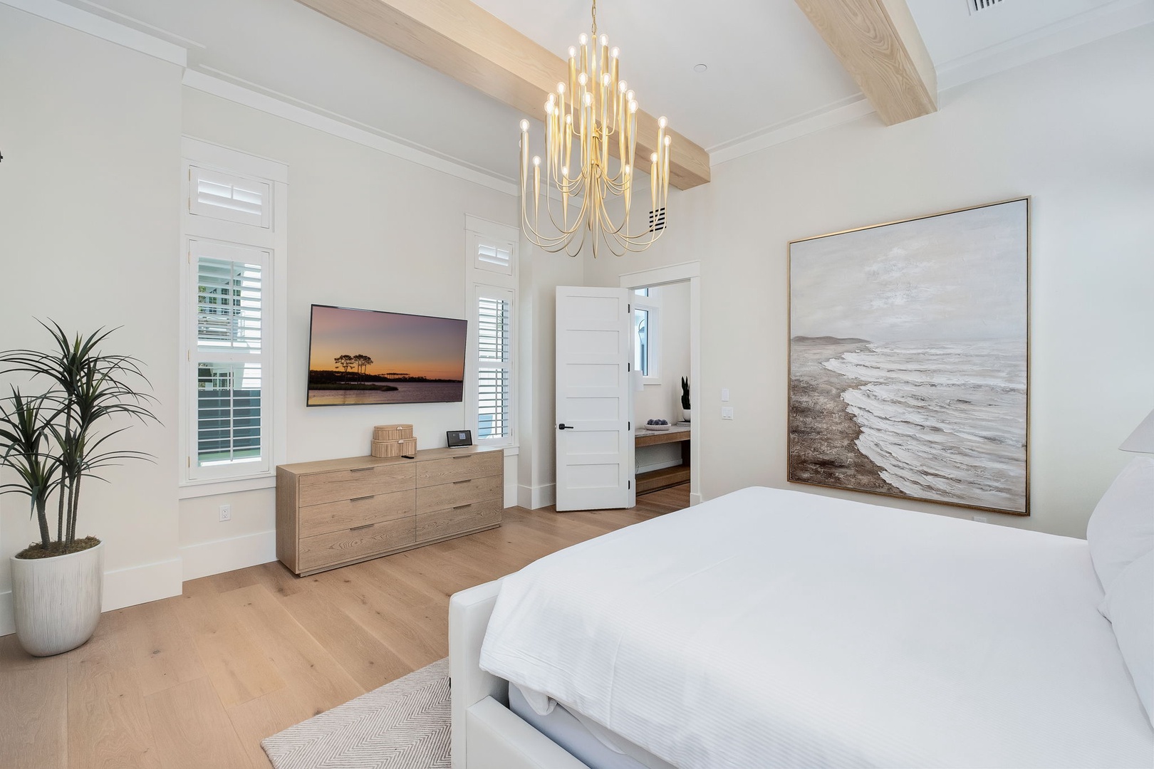 Unwind in your tranquil bedroom retreat with soaring vaulted ceilings, natural wood beams, and soft coastal light. Plush bedding and serene décor create the perfect escape after your day of exploring.