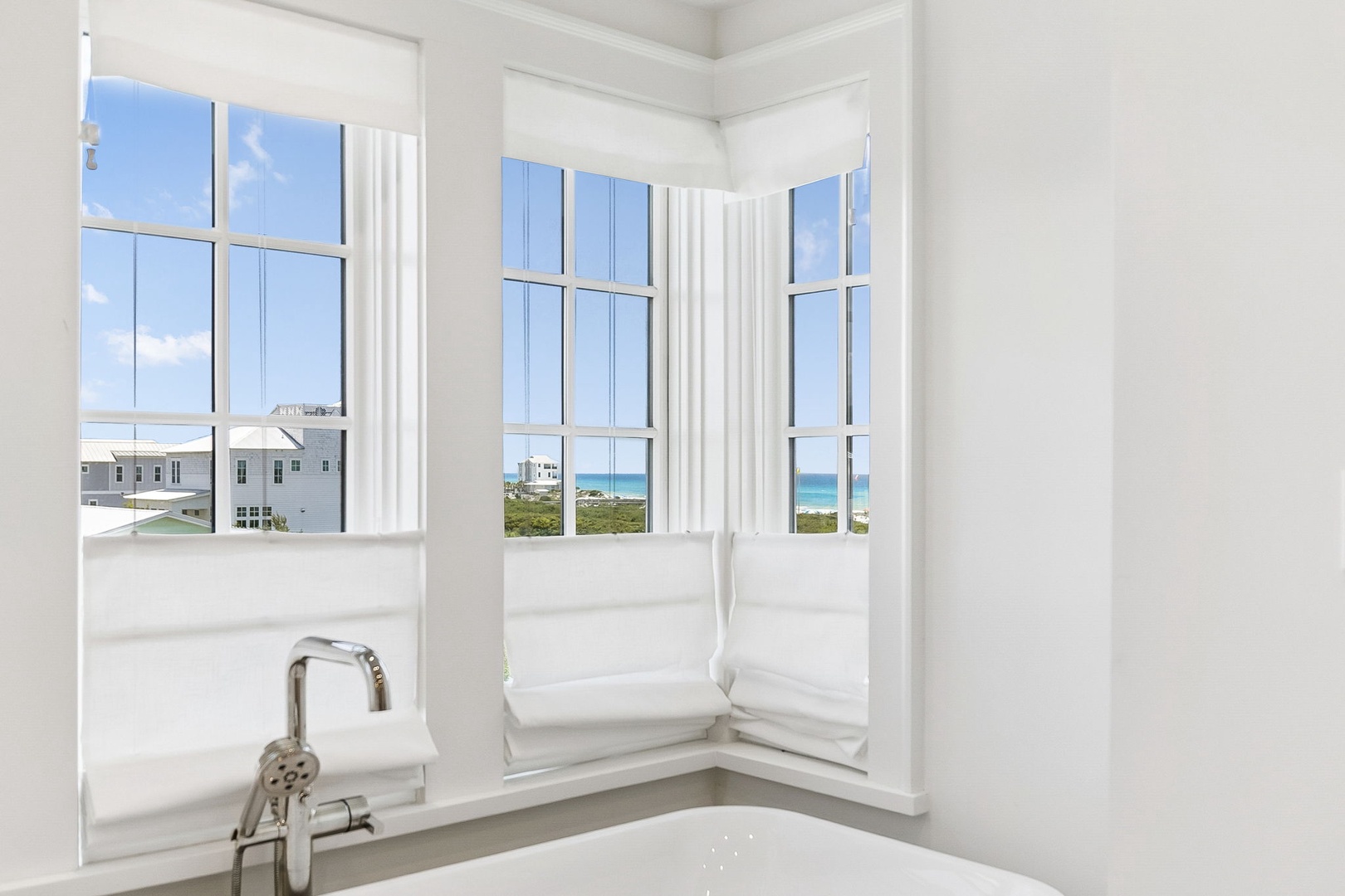 Soak in your freestanding tub while gazing at turquoise waters and coastal views through floor-to-ceiling windows—a serene escape designed just for your relaxation.