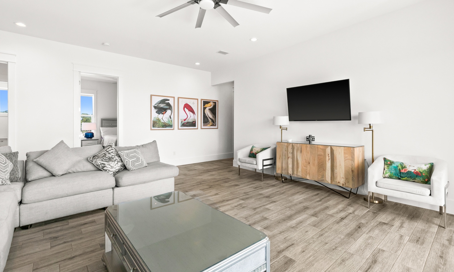 Settle into this bright, open living space with comfortable seating, a modern ceiling fan, and thoughtful touches that make you feel right at home.