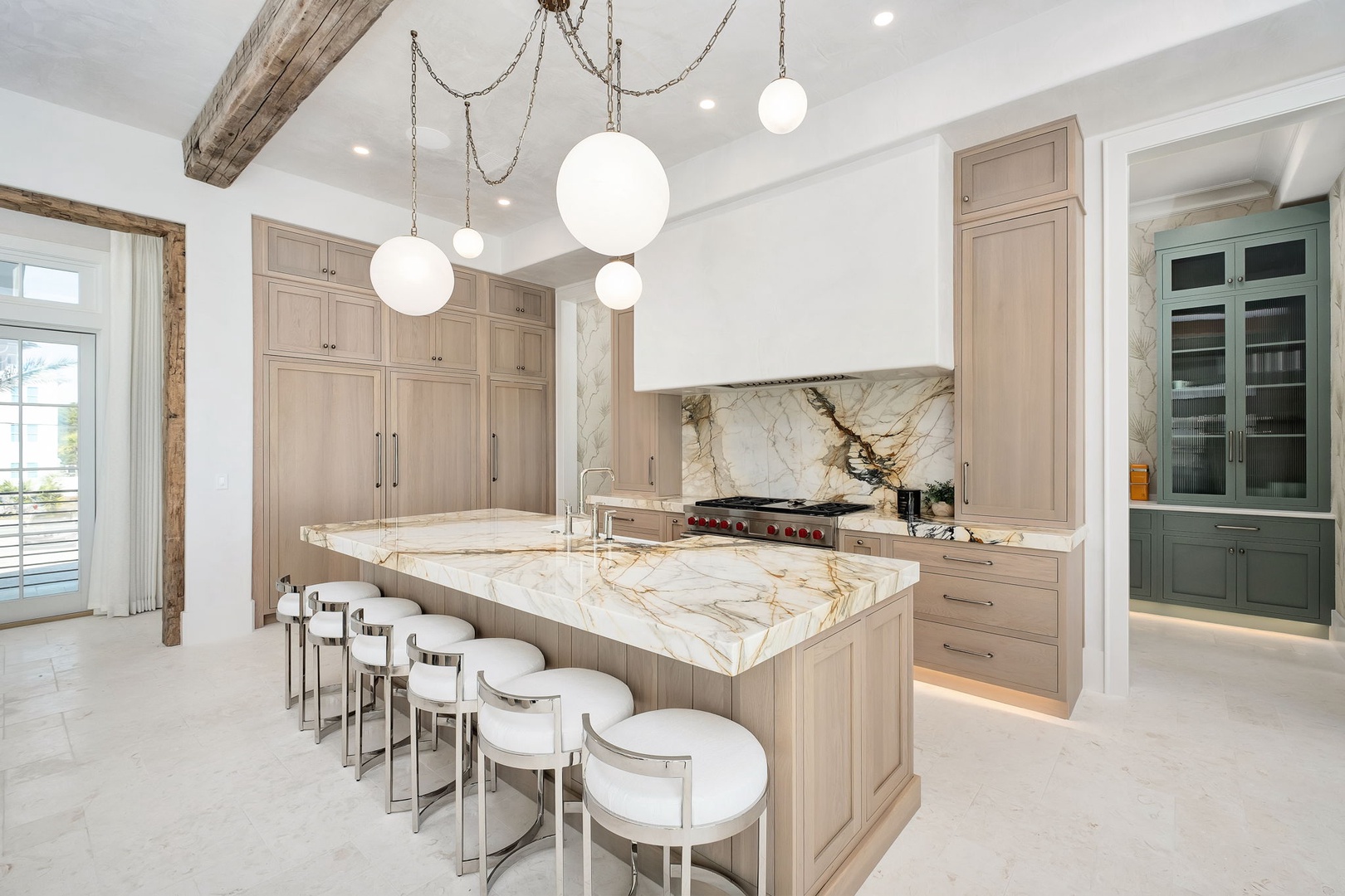 Your gourmet kitchen awaits with marble island seating, professional appliances, and warm wood tones for memorable meal preparations.