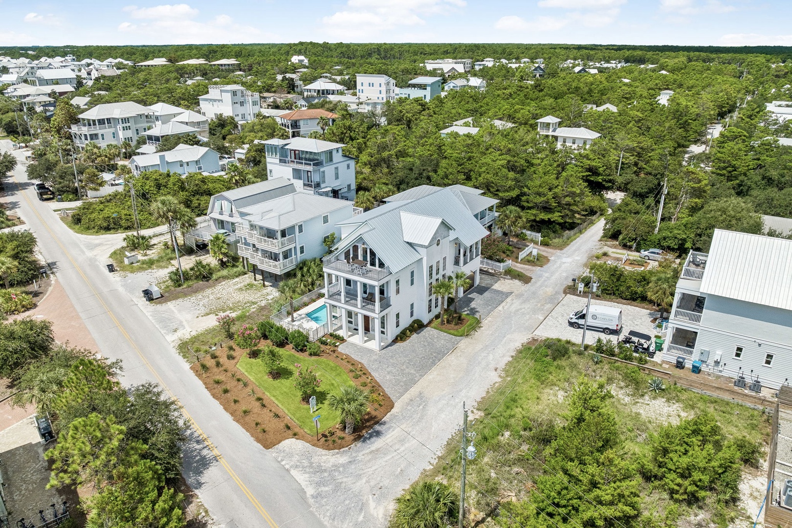 Aerial view of a coastal neighborhood showcasing lush greenery and charming residential architecture in a peaceful coastal community.